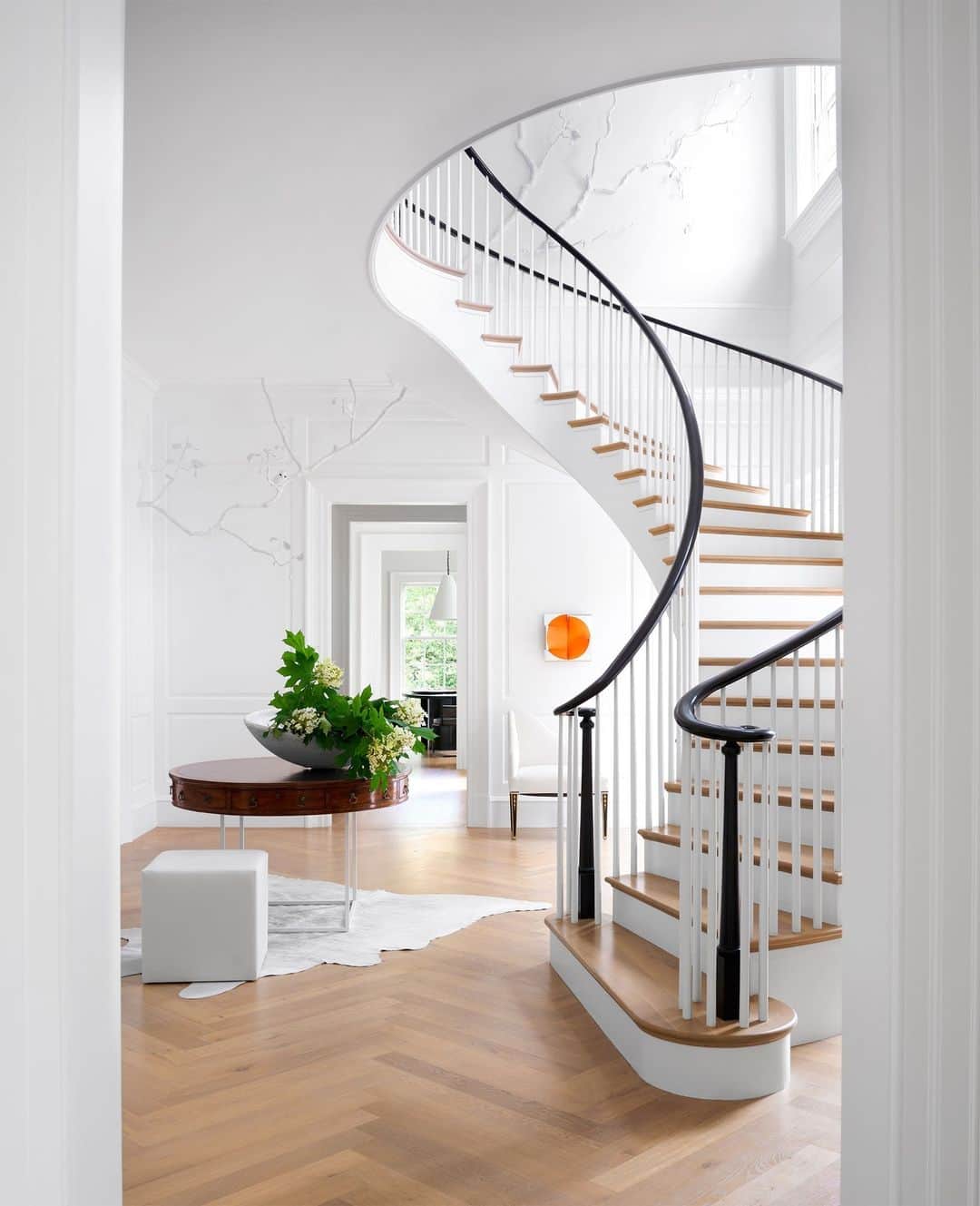 のインスタグラム：「Flaunt what you’ve got! The sweeping stair hall in this Georgian revival-style home certainly isn’t afraid to show off its curves. Just beyond, the artwork by @janmaartenvoskuil lends a hint of bold color to the otherwise light-and-bright room. “White is a very challenging color,” says ELLE DECOR A-List Titan Darryl Carter (@darrylcarterdesign) who collaborated with architect Anne Decker (@annedeckerarchitects) to design a home for a young family of five in Virginia. “The running joke in my office is how difficult it is to find the right white. It’s always ‘that white is too green, that white is too pink,’ and so on. This home is so highly nuanced tonally that you don’t even notice the complexity of how the furniture and textiles interact.”   Click the link in bio for a full tour of this regal home, as seen in our October 2023 issue. Written by @cokhio. Photographed by @williamwaldronphoto.」