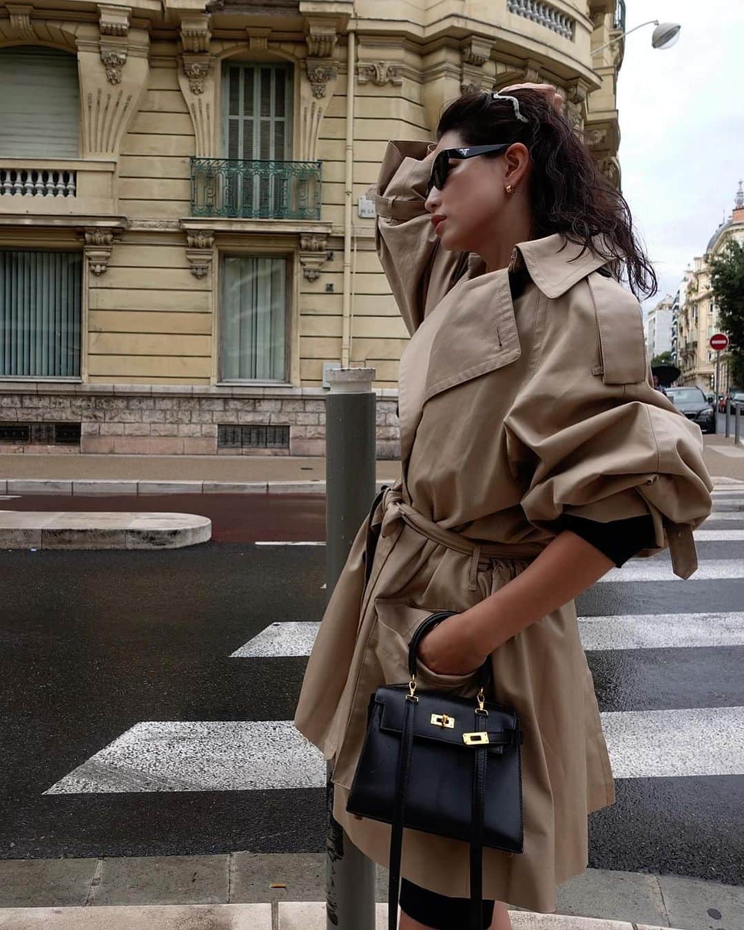 JUNNAのインスタグラム：「@aquascutum_japan @aquascutum × @etretokyo   🇫🇷にてコラボトレンチ🧥を着てショコラショ飲んで☕️♡  9月21日木曜日予約発売です(ご予約は27日12時まで) (ルミネ新宿店にて、S.Mサイズご試着可能です) ※大阪、名古屋POP UP STOREでのお取扱いはございません  軽量で強度があり光沢感のある上質なコート。 多くのアイテムやシーンに寄り添う丈感と、美しいシルエットに拘りました。   着用をかさね身体に馴染む感覚を楽しめる、一生もののトレンチコートです。  クローゼットの中でも一際輝く肉厚で丈夫なツイル素材。美しい表面感には惚れ惚れします。  撥水機能を備えており、フランスでの突然の土砂降りも水が水滴となって弾かれ、フードを被れば傘無しでも快適に過ごせました。  ウールのライナーが付いているので暖かく、さらにチンウォーマーで襟を立てればより防寒性も高まり真冬でもお召しいただけます。 袖周りはひろく厚めのニットも重ね着いただけます。  ライナーを取り外せば春の主役アウターへシフトも可能です。  裏地には、Aquascutumのアイデンティティを表す伝統のハウスチェック柄が使われており、ミリタリー感の残るマチのある大きなポケットやベルトに装飾されているDリングもディティールポイント。  オーバーサイズなシルエットと取り外し可能な大きめのフード、ウエストは中の紐で絞ることができ、ギャザーがたっぷりとたまるメリハリのあるシルエットと、女性らしいAラインシルエットの両方をお楽しみいただけます。  #aquascutum#ETRETOKYO #トレンチコート」
