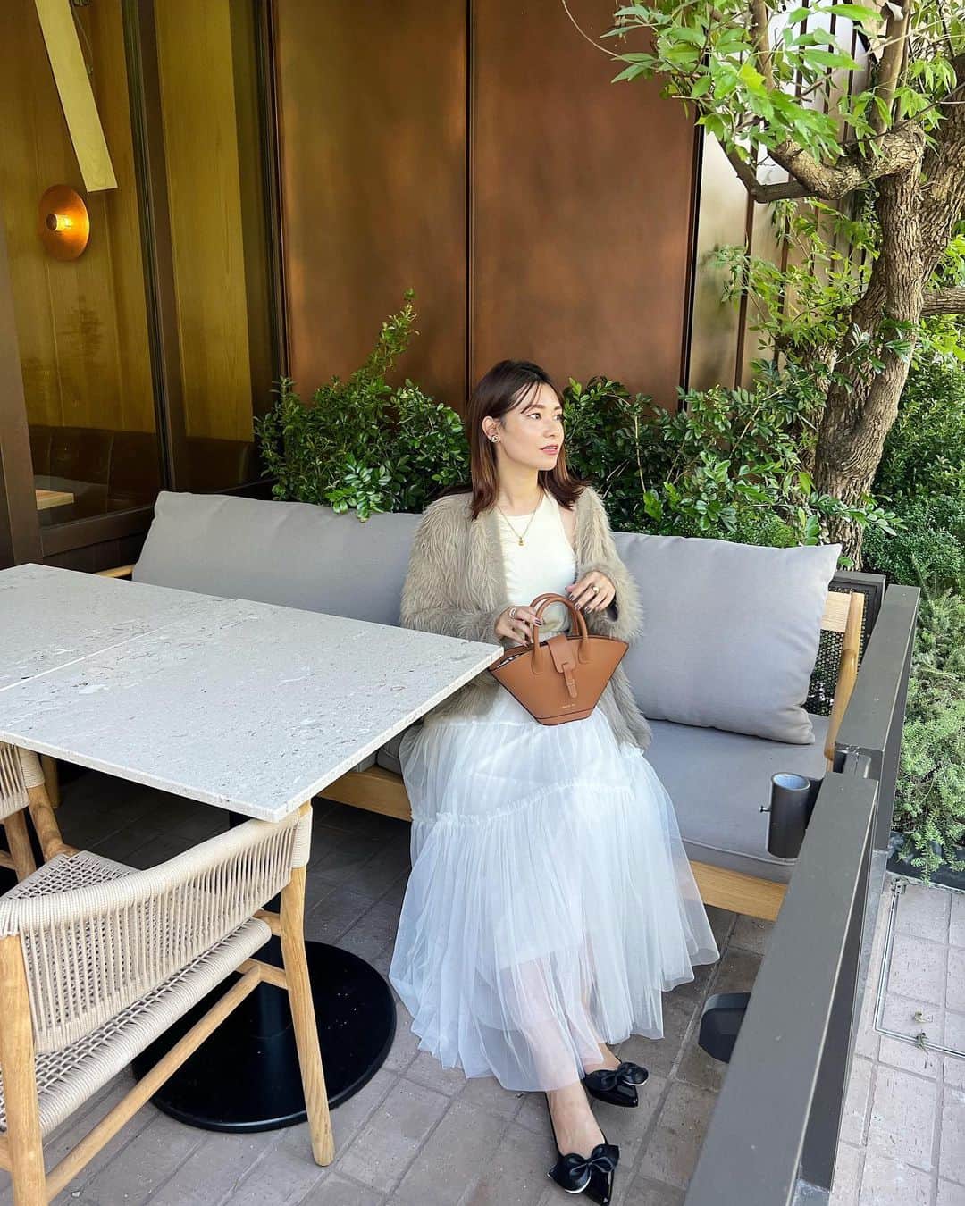 吉田奈央のインスタグラム：「たまにはガーリック🧄  ではなくガーリーなわたし。  ちょい甘も好きですよ❤︎  もふもふニット @ur_fbyrosso   が一気に上品さだしてくれてお気に入りです🥺💓  この色合いもどツボなの🤭  バッグは @paris64world   デザインが可愛すぎました👜  ランチした場所もとても可愛かったよ🍽 泊まってみたい❤︎  #fbyrosso#秋服コーデ#きれいめコーデ#大人可愛いコーデ」