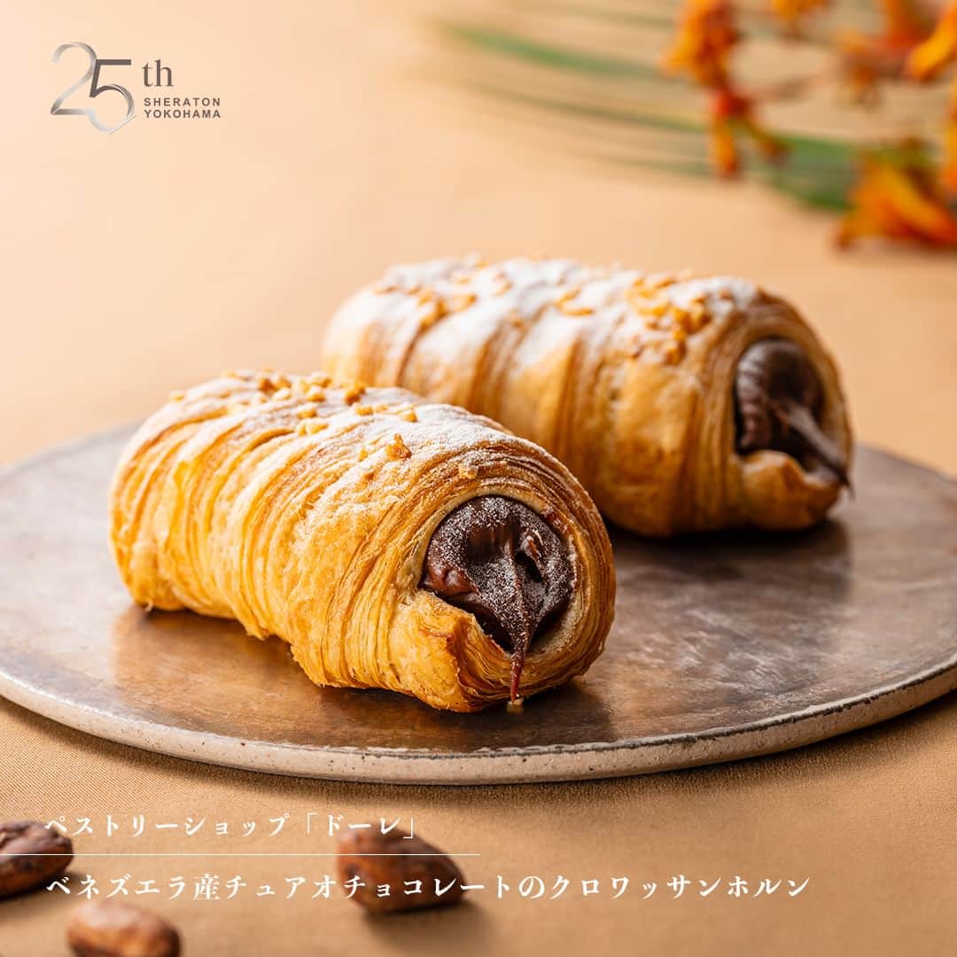 のインスタグラム：「【開業25周年企画】 ベネズエラ産チュアオチョコレートのクロワッサンホルン🥐🍫  開業以来25年間愛され続けるペストリーショップ「ドーレ」のクロワッサンに、ベネズエラ産カカオ"チュアオ"のハイミルクチョコレートを使用した「クロワッサンホルン」を10月末まで販売いたします。  ベネズエラ産チュアオチョコレートのクロワッサンホルン ■場所：ペストリーショップ「ドーレ」 ■期間：9/1(金)～10/31(火) ■料金：￥490(税込)  これまでの皆様のご愛顧に感謝の気持ちを込め、開業25周年を記念した様々なメニューや商品をご提供いたします。 ご予約、詳細はプロフィールのリンクの「最新情報はこちら」の「横浜ベイシェラトン開業25周年記念企画」から➡️ @sheratonyokohama　　  #横浜ベイシェラトン #横浜ベイシェラトン25周年 #横浜 #横浜ホテル #横浜駅 #横浜パン屋 #パン #ベーカリー #クロワッサン #クロワッサンホルン #チュアオチョコレート #パン活 #パンスタグラム #sheratonyokohama #sheraton #yokohamahotel #yokohama」