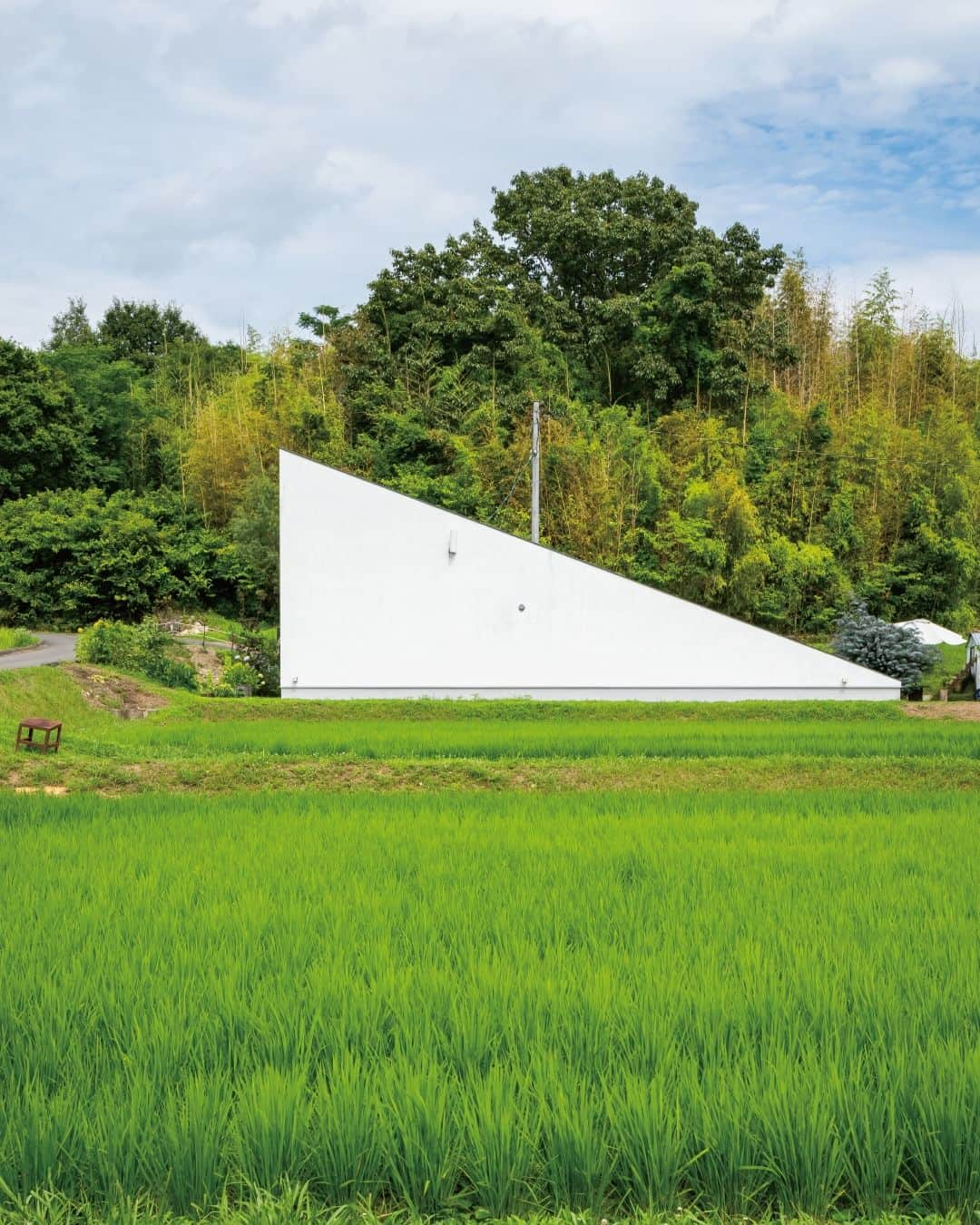 321houseさんのインスタグラム写真 - (321houseInstagram)「田園風景の中に建つ白い三角の建物。 田んぼと山の緑に囲まれ、ひときわ目を引きます。 . 人通りのある道からはほとんど壁しか見えませんが、 実は大きな窓から光と緑がたくさん取り込める 開放感のある住まいです。 . ミツイハウスの常設モデルハウス「sankaku」に似た、 こちらもまさに三角のお家。 お家に帰るのが何だかワクワクしそうです。 . HPでは入居されてすぐの頃と、7年経った状態とで お写真をご紹介させていただいています。 センスあふれるお住まいをぜひご覧になってください✨ . HPでは他にも様々な事例をご紹介しています。 ミツイハウスの施工事例、モデルハウスや イベント案内など、プロフィール画面から HPへお進みいただきチェックしてみてください🙂 . . #東広島 #広島 #モデルハウス #注文住宅 #平屋 #新築 #新築戸建て #マイホーム #家づくり #木のある暮らし #木の家 #自然素材の家 #自然素材 #シンプルな家 #自由設計 #自由な間取り #デザイン住宅 #こだわりの家 #設計士とつくる家 #家事動線  #外観 #おしゃれな外観 #白壁の家 #こだわりの外観  #中庭 #中庭のある家 #ウッドデッキ  #321ハウス #321house」9月20日 19時00分 - 321house