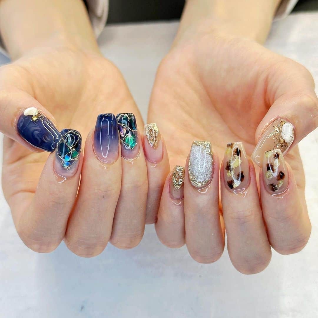 宮川春蘭のインスタグラム：「. #アーカイブ . 今月もこだわりぎゅうぎゅうヅメのネイル💅 左手は秋先取り🍂 右手は誕生石のサファイアをイメージして、どうしてもネイビーを入れたかったデザイン🫶 . . 東京に越してきてネイルサロンが定まらなかったけど、ようやくずっと通いたいサロンを見つけたよ🥹 @aimi.tk_nail  ジェルやパーツの種類が豊富、サンプルデザインが可愛いのはもちろん、 持ち込み画像を、画像以上に可愛くしてくれるのすごすぎん？ あとお姉さんが爆裂美人です🫶 東京でネイル難民の方強くおすすめです！！」