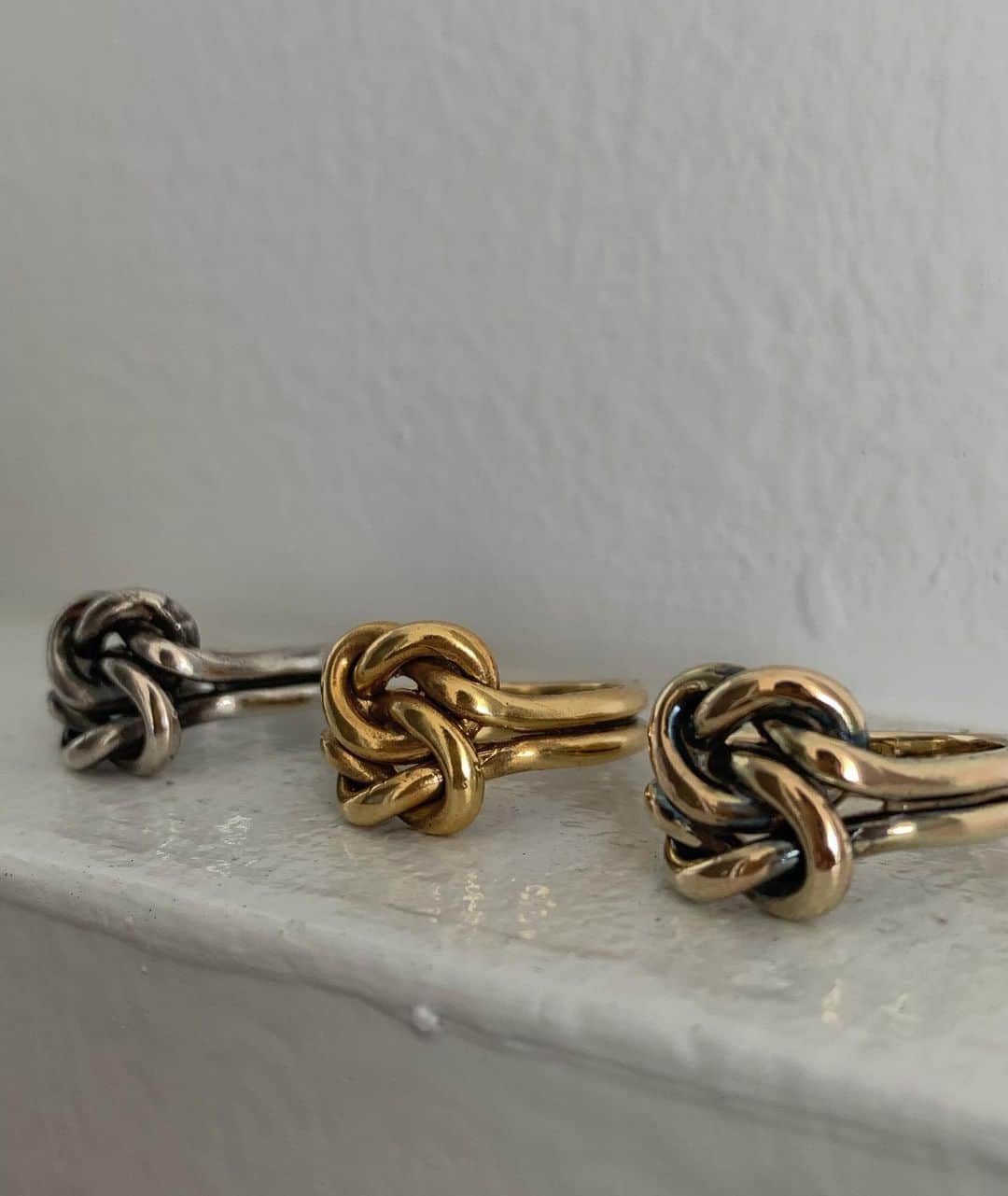 馬渕真由子のインスタグラム：「身内人気が高いknot ring。  ノットは古くから用いられてきたデザインで、途切れることのない縁や愛、絆を意味します。  地金を贅沢に使用したボリューム感のあるデザインながら、モードにもカジュアルにもシンプルにもどのようなファッションにも合うデザインになっています。(こだわりポイント)  使用する地金によって色味と雰囲気が変わるのでその辺りもお好みでお選びいただけたらなと思っております。 左からSV925/SV925＋K18gpt/K10 (画像にはないのですがK18もご用意しております)✍️」