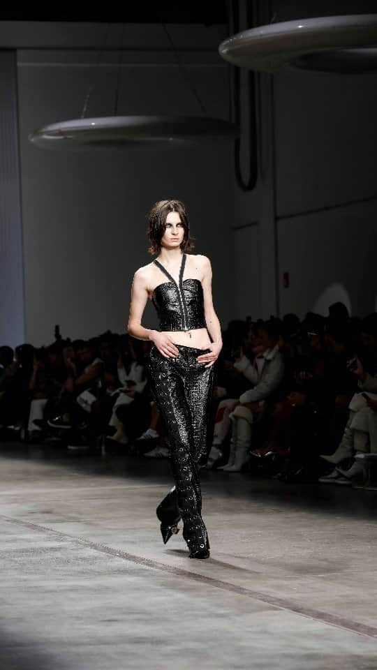 アイスバーグのインスタグラム：「ICEBERG Spring Summer 2024 co-ed show. Black embossed croc faux leather bandeau tops are cut with a zip at the front, the zip turning into shoulder straps; black cutaway bikers in embossed croc faux leather are worn with matching mini-skirts, over cutaway swimwear finished with I circle hardware.  Discover all the looks at iceberg.com   #iceberg1974 #iceberg #icebergSS24 #MFW」