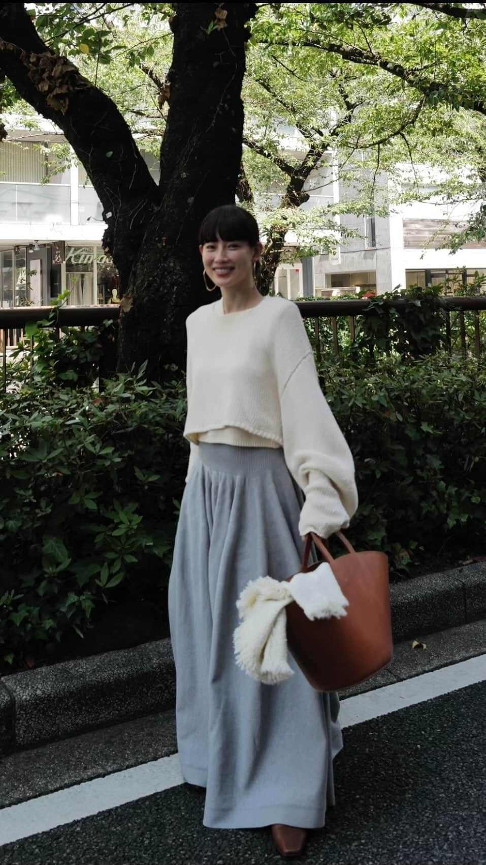 JUNNAのインスタグラム：「この秋一番気に入っている 今すぐ大活躍するニット🧶のご紹介です  コットンを編み立てたベストとロングスリーブのプルオーバーがレイヤードされた #ETREツーピースクロップドニット  ２つのトップスは同じ糸ですが 違う編み地なので、重ねると可愛さ倍増  まだまだ暑いので、今はベストを楽しんで、気温が下がって来たら二枚重ねてお楽しみ下さい♪  スカートは悩んで、グレーとライトブルーをオーダーしました  週末の韓国🇰🇷旅行✈️に着ていく予定🗓️♡  tops/ #ETREツーピースクロップドニット skirt/ #ETREニットボリュームスカート shoes/ @maisontherow  bag/ @laurenmanoogian  stole/ @asaucemeler  #etretokyo#中目黒#散歩」