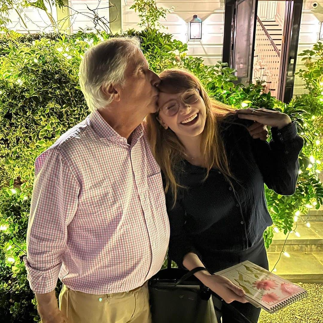 ブライス・ダラス・ハワードのインスタグラム：「I love my family ⁣⁣ ⁣⁣ ⁣ ⁣ [ID 1: BDH celebrates a dinner at The Winklers. Outside by the bushes, godfather Henry Winkler (left) kisses BDH (right) on the head as they wrap their arms around each other.]⁣⁣ ⁣⁣ [ID 2: BDH (left) sits next to her god sister Zoe (right) on a staircase. The two are as close as can be — in proximity, friendship, and hair type.]」