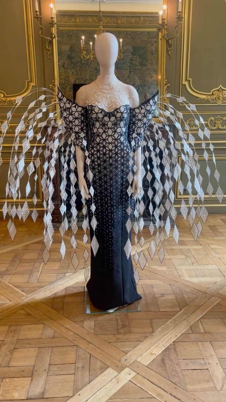 Iris Van Herpeのインスタグラム：「Delicate details <> The daring craftsmanship of this gown is developed from a parametric pattern that explodes skilfully into a voluminous silhouette. The smooth color gradient is created by laser-cutting a black microfiber in which fine lace is inlaid. Fiberglass rods are carefully hand-stitched into the sculptural sleeves to create a transformative figuration of fluidity.  #irisvanherpen #hautecouture #architectonics」