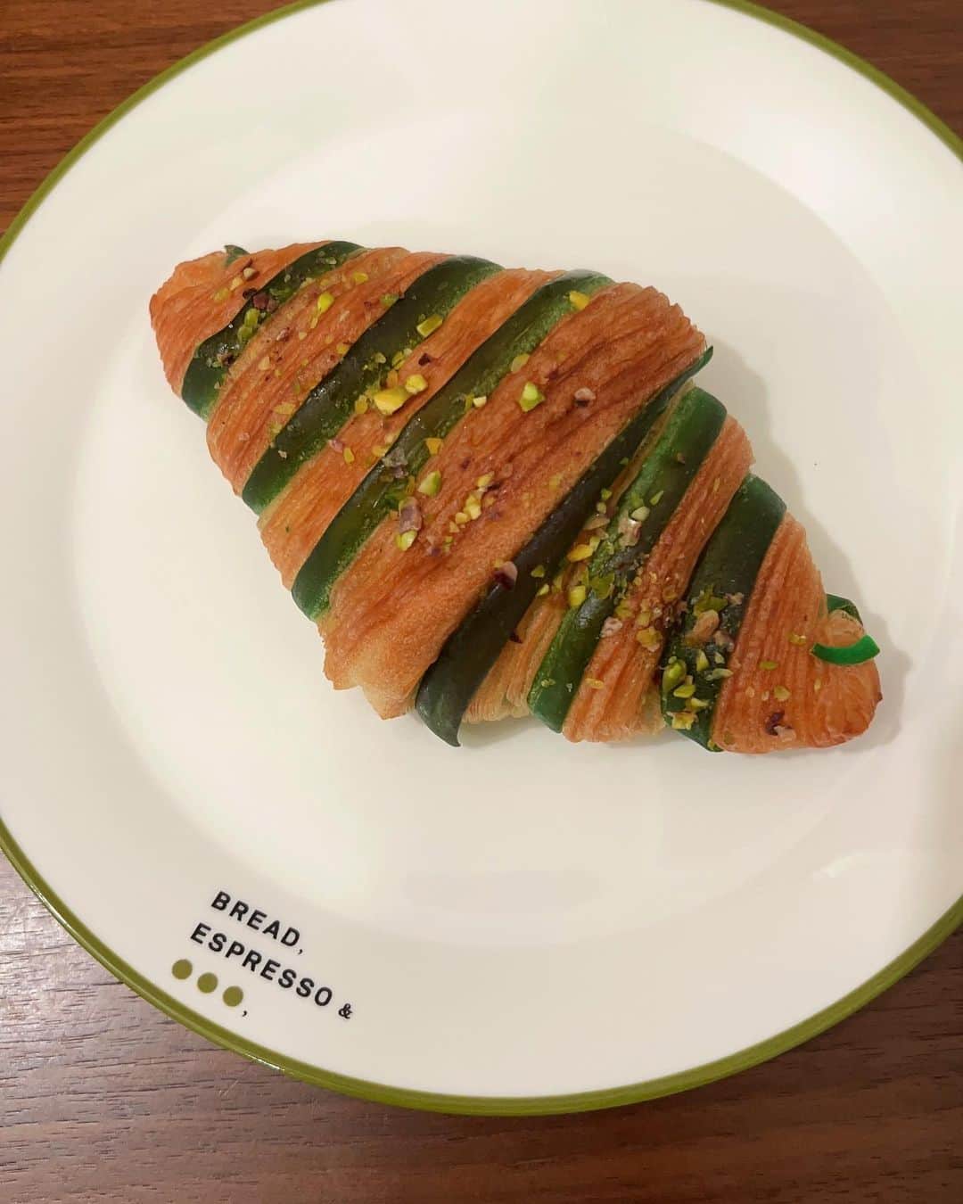 上村祐翔のインスタグラム：「ピスタチオクロワッサン🥐 彩り豊かなピスタチオがふんだんに使われた一品！ マーブルなデニッシュ生地が可愛い✨ 食べるとパリッとしたクロワッサンの食感と、なかにはトロッとしたピスタチオクリームが😳 濃厚な香りと味を堪能しました！ ごちそうさまでした😋 #ウエムラ今日もパン祭り」