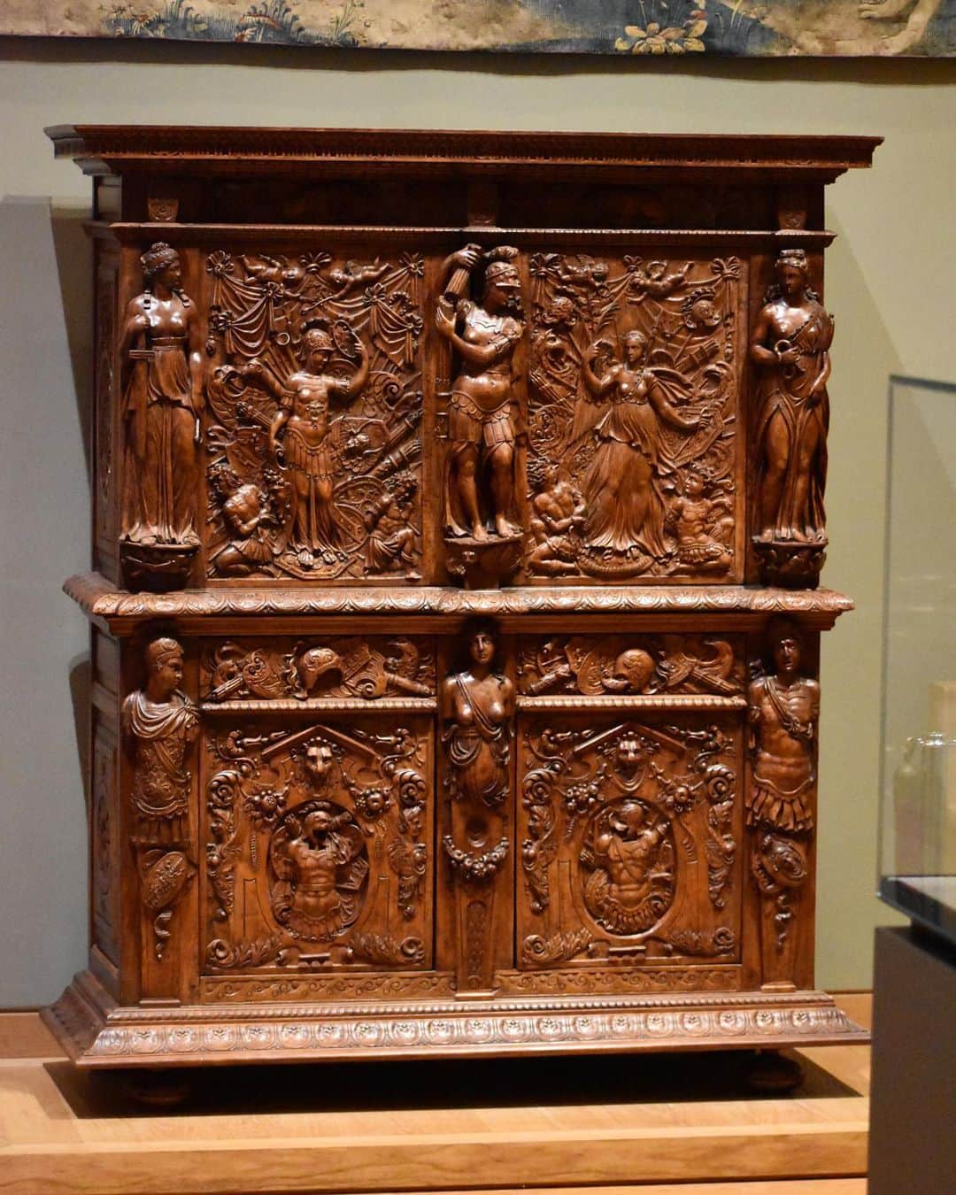 のインスタグラム：「. 🇫🇷 Inspectons les œuvres du musée avec #LouvreALaLoupe ! Aujourd’hui, intéressons-nous à cette armoire réalisée à la fin du 16e siècle. - 🪵 Cette armoire à deux corps est en bois de chêne pour le bâti et en bois de noyer pour la façade et les côtés. Le riche décor sculpté, d’une qualité exceptionnelle, se développe de manière très dense sur quasiment toute la façade jouant sur tous les niveaux, du bas-relief à la ronde-bosse.   - ⚔️ Le programme iconographique du décor décline la thématique de la guerre : les deux figures de Victoire soumettant leurs ennemis occupent les vantaux supérieurs alors que des trophées d’armes se déploient sur le reste de la façade.  - 👀 La qualité de la sculpture, la richesse iconographique et le soin apporté aux détails permettent de penser que ce meuble provient sans doute d’un des meilleurs ateliers de menuiserie de l’époque. Une attribution à Hugues Sambin, menuisier de la Renaissance en activité à Dijon depuis les années 1550 jusqu’à la fin des années 1580, est envisagée.  ∴ 🌎 Let's inspect the museum's works with #LouvreALaLoupe! Today, let's take a look at this late 16th-century cabinet. - 🪵 This two-part cabinet is made of oak and walnut. The rich carved decoration, of exceptional quality, develops very densely over almost the entire facade, playing on all levels, from bas-relief to ronde-bosse.  - ⚔️ The iconographic program of the decor reflects the theme of war: the two figures of Victory subduing their enemies occupy the upper casements, while trophies of arms are displayed on the rest of the façade.  - 👀 The quality of the carving, the wealth of iconography and the attention to detail suggest that this piece of furniture undoubtedly comes from one of the finest joinery workshops of the period. An attribution to Hugues Sambin, a Renaissance joiner active in Dijon from the 1550s to the late 1580s, is being considered. - 📷 © Musée du Louvre / Nicolas Bousser  . . . #Louvre #MuséeDuLouvre」