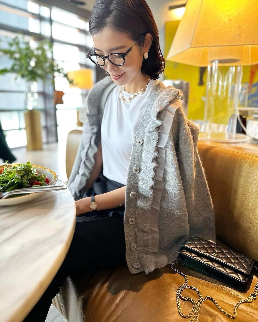 のインスタグラム：「・ 珍しく外でスタッフとブランチミーティング💕 ちょっと秋めきたかったので、Tシャツの上にカーディガンと、サンダルにソックスを🧦  Tシャツ黒パンにシンプルなカーデだと私には少し甘要素が足りないから、フリルとオーガンジーのカーディガン🩶 切りっぱなしのオーガンジーと、ふわふわのニットの組み合わせがたまんない🩶🩶🩶 ふわふわの見た目だけど、毛も抜けにくいアルパカ混の素材にしました☺️👌」
