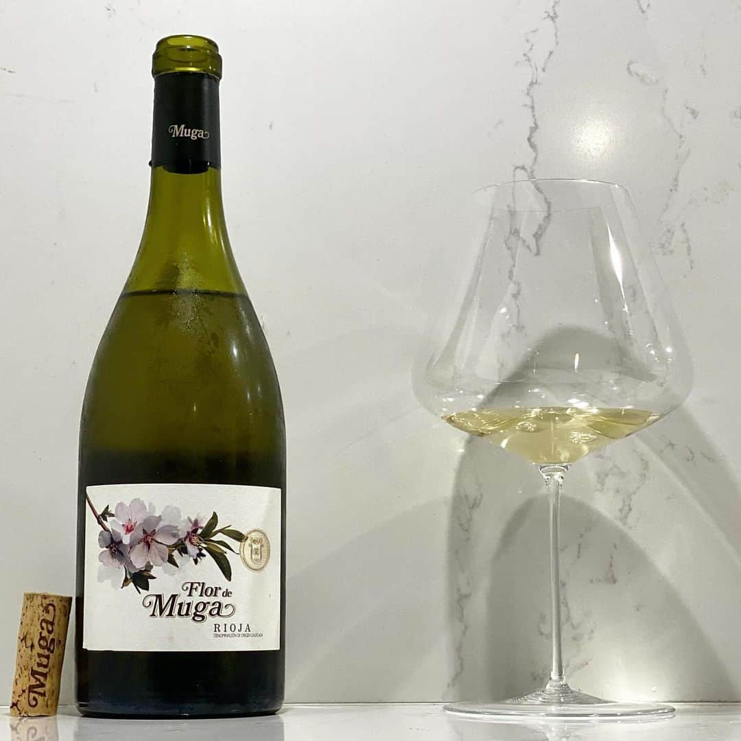 エンリケ・ソラ・クレメンテのインスタグラム：「Flor de Muga Blanco 2018 de Bodegas Muga, DOCa Rioja. El primer Muga Blanco envejecido en barrica fue elaborado en 1973. Pero en aquella época, la demanda de este tipo de vinos no estaba muy extendida, por lo que la bodega decidió centrarse en la elaboración de vinos tintos. En 2021 Bodegas Muga lanza “Flor de Muga Blanco 2018”. Es el ensamblaje de las variedades de Viura, Garnacha Blanca y Maturana Blanca, que tras un breve periodo de maceración dentro de la prensa, se selecciona el mosto flor y a continuación pasa a fermentarse a baja temperatura en pequeñas barricas de roble. Al final del proceso de fermentación, el vino permanece con sus finas lías durante un periodo de 3 meses en un “Oeuf de Beaune” (depósito de hormigón con forma de huevo). Posterior crianza durante 6 meses en barricas nuevas, elaboradas en su propia tonelería, de roble francés. El vino pasa otro periodo de afinamiento en botella de 18 meses para obtener un mayor refinamiento y redondez. Cremosidad, elegancia y complejidad. Degustado en Zalto Denk’Art Burgundy Glass. Bodegas Muga es una empresa familiar fundada por Isaac Muga y Aurora Caño en 1932 ubicada dentro del emblemático Barrio de la Estación de Haro. Se trata de un edificio bicentenario con gruesos muros de piedra que preservan las condiciones óptimas y que, en combinación con tinos y barricas de madera construidos en su tonelería, forman un binomio perfecto para el cuidado de los vinos. Son la única bodega de España con un maestro cubero y tres toneleros propios. Elaboran sus barricas con el mejor roble, dándoles el tostado interior adecuado para conseguir vinos de carácter único. Feliz fin de semana!!!  ———————————————  #wine #winelover #winetasting #winetime #winery #winestagram #redwine #wineoclock #foodandwine #instawine #winelife #wineporn #whitewine #winenight #champagne #winenot #winetour #sommelier #vin #🍷 #vino #vinho #wein #cheers #vineyard #bodegasmuga #flordemuga #riojawine #barriodelaestacion #zaltify」