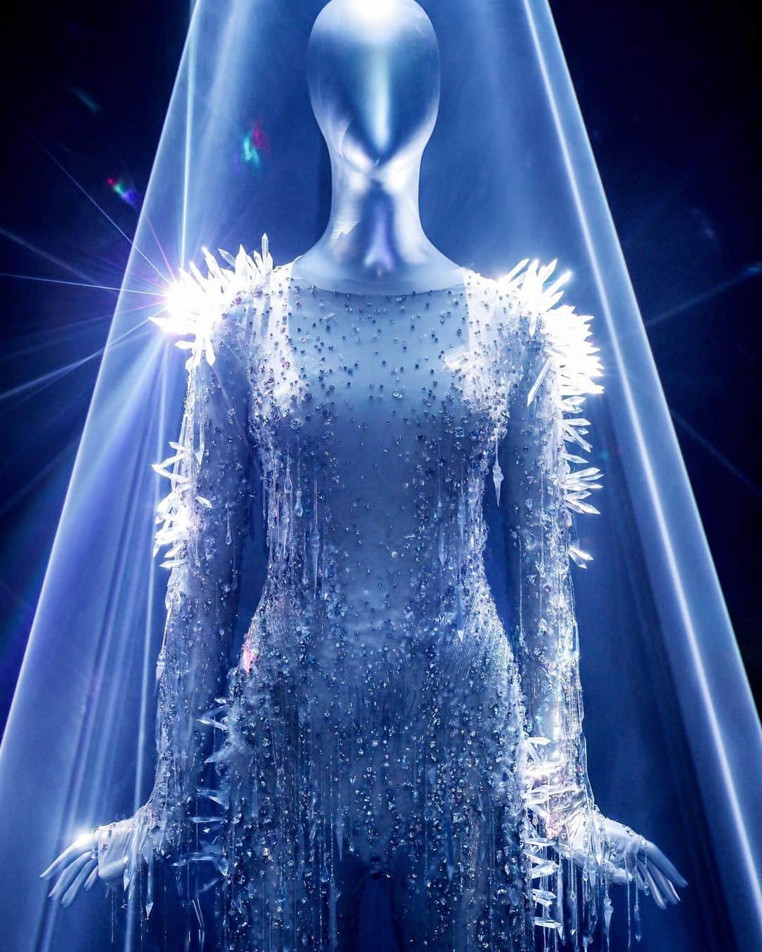 ミュグレーのインスタグラム：「Mugler Archives for @swarovski ‘Masters of Light’ exhibition @mocashanghai curated by @alexanderfury - Featuring an all over crystallized bodysuit from the Spring Summer 1998 Haute Couture ‘Jeu de Paume’ collection, and an all over embroidered smoking dress from the Fall Winter 1992/93 Haute Couture ‘Ritz’ collection. #mugler #muglerarchives」