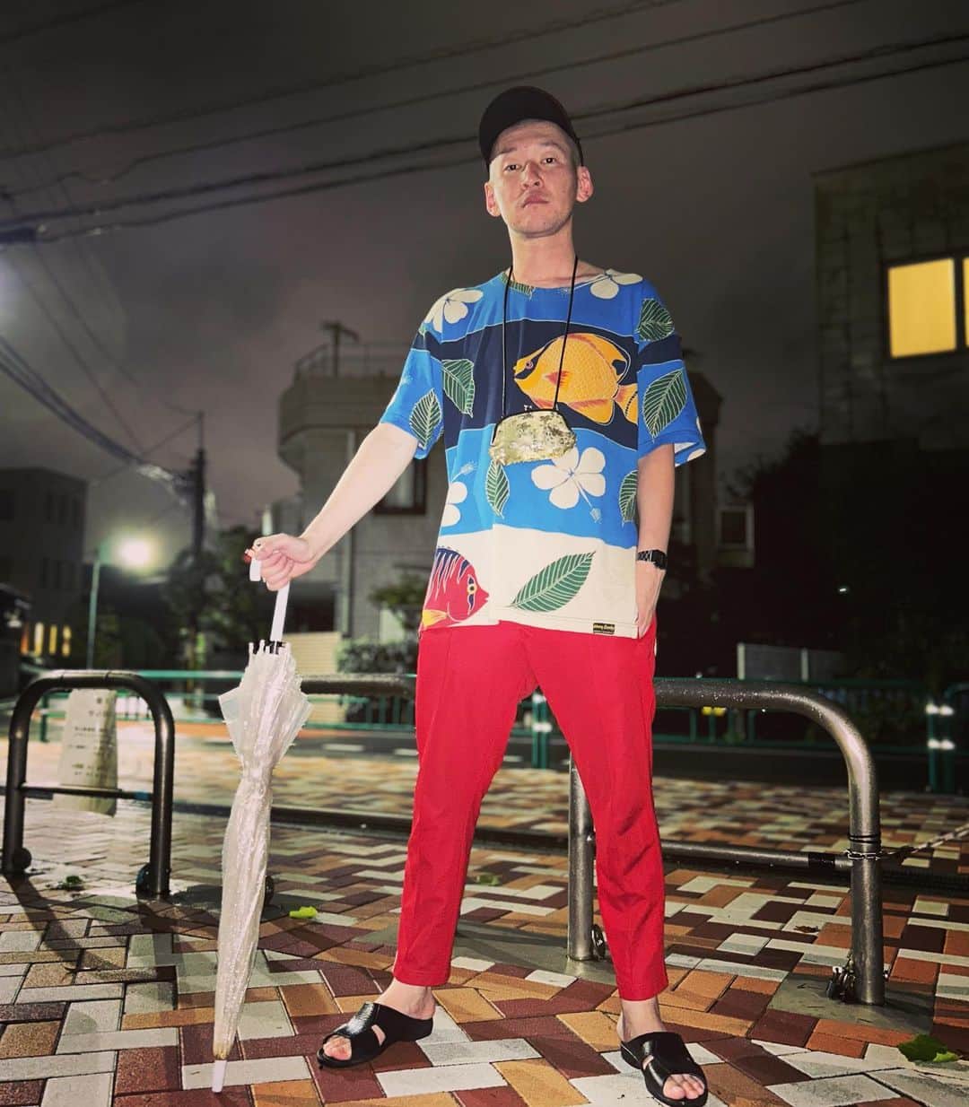 のインスタグラム：「今日の服装。 雨がどしゃ降りしたりの日。  メチャメチャで購入した魚のTシャツ。 adidasの赤ジャージ。 無駄づくりの黒帽子に黒の便所サンダルと金のがま口でビニール傘。 あぶねえあぶねえ。 夜が過ごしやすくなってきた夜撮りました。 夜ありがとう。  #今日着た服 #ファッション #古着 #夜 #雨 #深夜すぎ」