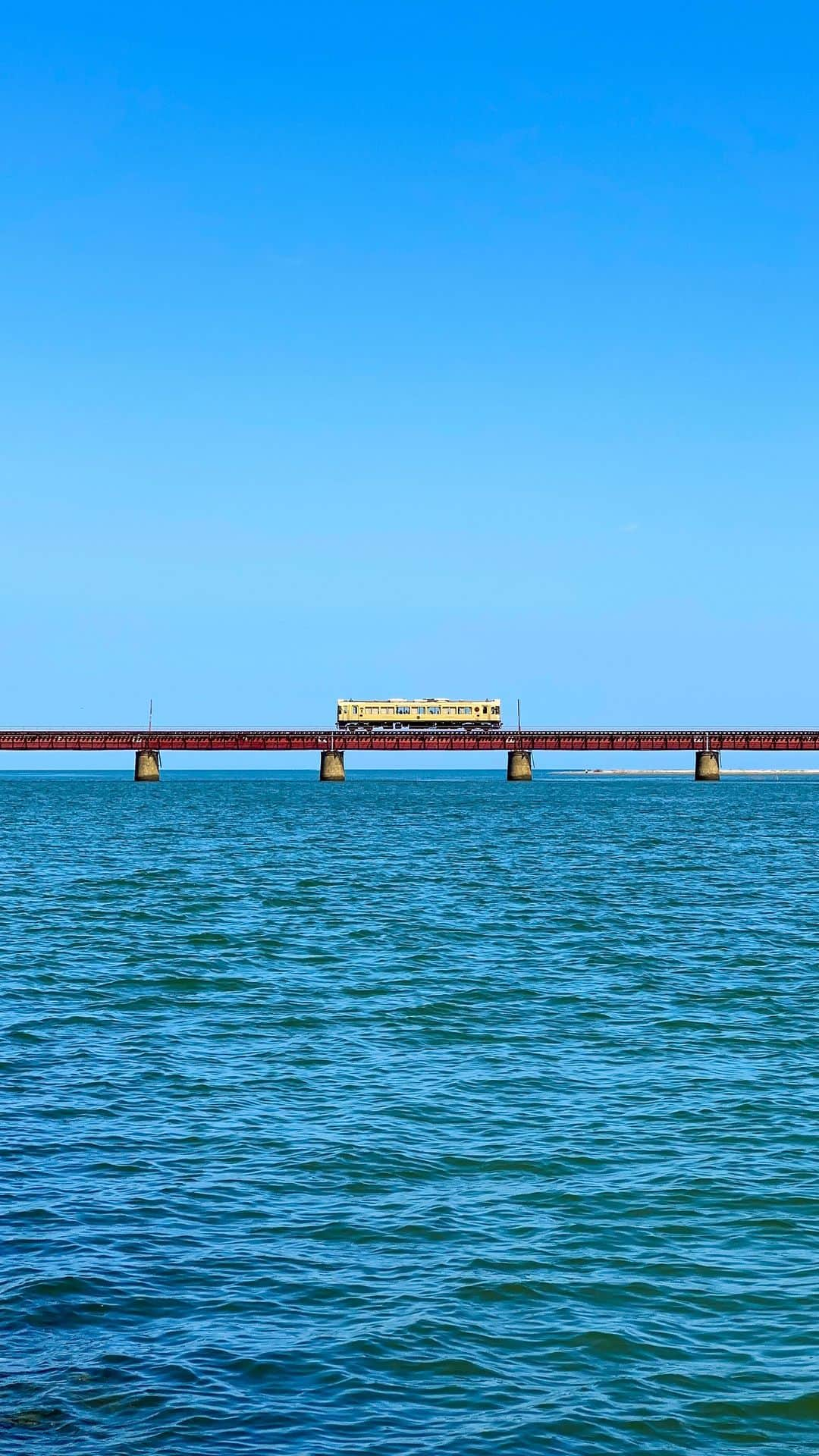 詩歩のインスタグラム：「Blue sky and blue sea.Red bridge and yellow train.  The #YuragawaBridge in northern Kyoto, the first time I visited in 4 years. It is a famous spot for railroad photographers. The #KyotangoRailway running along the straight bridge was like something out of a movie.  青い空と青い海。赤い橋と黄色い列車。  久しぶりに訪れた京都北部にある #由良川橋梁 。 まっすぐ伸びた橋梁を走る #京丹後鉄道 はまるで映画の世界のようでした。  🇯🇵 #shiho_kyoto  📷18th Sep 2023 📍京都府 由良川橋梁 / Yuragawa Bridge,Kyoto JAPAN  ©︎Shiho/詩歩」