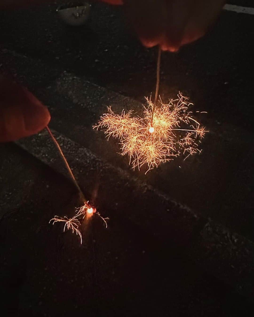 のインスタグラム：「_ あゆちゃんちで夏の終わりに花火  詩珠は産まれて初めての 手持ち花火に終始顔は　"無" でしたが（笑） 自分で火つけてちゃんと終わったら 火消しに行ってってしてました😌  ジュース飲みながら花火やってたけどな🫣  夏感じて楽しかったな〜  私もあゆちゃんも仕事終わりに ボサボサやけど思い出📷  あゆちゃんの足元は👵🏼♡（笑）」