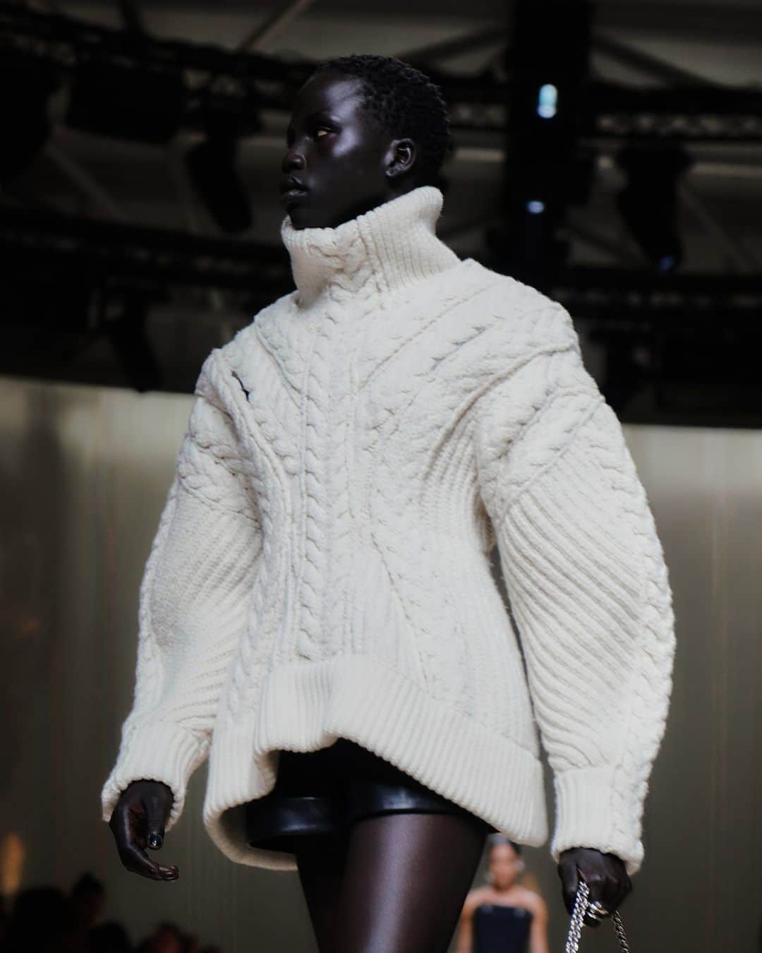 アレキサンダー・マックイーンのインスタグラム：「A #McQueenAW23 ivory cable knit jumper and black shorts worn with the Slash Flare boots.⁣ ⁣ Discover the collection via the link in bio.⁣ ⁣ Photographed by @RubyPluhar ⁣ Video by @indigital.tv⁣ ⁣ Sleep cycling by Rob Lewis⁣ Now Is⁣ Written and performed by Rival Consoles⁣ Courtesy of Erased Tapes⁣ 23:52⁣ Written by Nils Frahm & Olafur Arnalds⁣ Performed by Nils Frahm & Olafur Arnalds⁣ Used by Permission of Manners McDade Music Publishing Ltd.⁣ Courtesy of Erased Tapes」