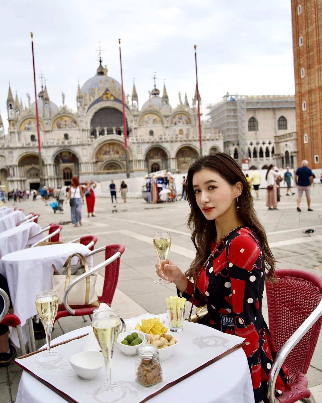 平山美春のインスタグラム：「📍𝐕𝐄𝐍𝐈𝐂𝐄  イタリア中心にヨーロッパ巡り🇪🇺 １年ぶりにVenice にも🇮🇹  世界で一番美しい広場と言われているサンマルコ広場で朝カフェを飲むのが気持ちよくて大好き！(ちゃっかりフランチャコルタ飲んでるが)  17世紀からあるグランカフェ・クアードリに立ち寄ることが多くて、テラスの席が赤いから赤の入ったワンピースで✨  旅に持ってきたFujiko @fujiko_brand のプランピーリップ04は秋らしいテラコッタ感のある馴染みやすい赤リップで、乾燥せずプランプ効果もあってオススメ！  ベリーに発祥の地であるハリーズバーに行ったり、船に乗ったり、もう少し短い滞在にしようと思ってたけど、居心地が良すぎて滞在を少し延ばしたくらい！  初めてヴェネツィアに行ったのは高校の修学旅行の時だったけど、当時から色褪せない魅力で何度来てももっと好きになる場所！  みんなにもそういう場所ってありますか？😊  #venezia  #italy」