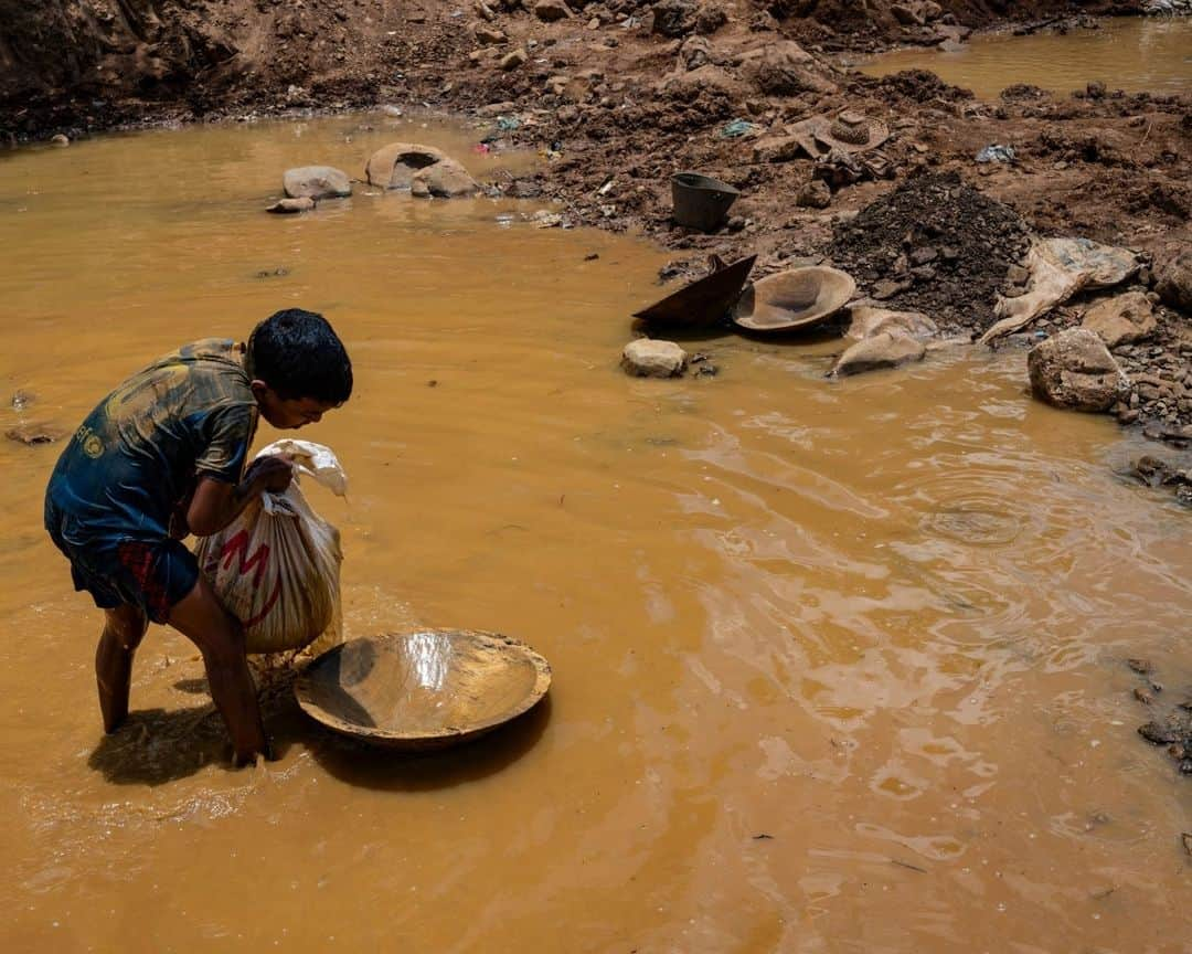 AFP通信さんのインスタグラム写真 - (AFP通信Instagram)「Gold and mercury, not books, for Venezuela's child miners⁣ ⁣ In the Venezuelan town of El Callao, extracting gold from soil starts as a kid's game, but soon becomes a full-time job that human rights activists slam as dangerous exploitation.⁣ Small and agile, the children's size helps them shimmy into narrow wells to hack out muddy earth, hoping it will contain gold -- which has become ever more precious as Venezuela's oil production has plummeted⁣ ⁣ 1 - A miner wearing a shirt with the image of "Uncle Sam" digs in a mine to extract gold, which will then be sold in El Callao, Bolivar State, Venezuela.⁣ ⁣ 2 - A miner works with a bar to dig and extract gold.⁣ ⁣ 3 - A miner shows rocks with traces of gold found in a mine to later be processed by hand in a mill in El Callao.⁣ ⁣ 4 & 5 - Mining children work digging in a mine in search of gold.⁣ ⁣ 6 - A young miner carries a bag of mud in an open pit mine in search of gold to later sell it in El Callao.⁣ ⁣ 7 - A mining boy unloads a bag of mud into a wooden container used to strain and wash mud in search of gold.⁣ ⁣ 8-> 9 - A young  miner strains and separates mercury from the mud used to adhere gold found in an open pit mine⁣ ⁣ 10 - A mining boy shows a ball of mercury that is used daily to separate the gold found among mud puddles.⁣ ⁣ 📷 @magdagibelli⁣ 📷 @yrispaul_21⁣ #AFP」9月24日 20時00分 - afpphoto