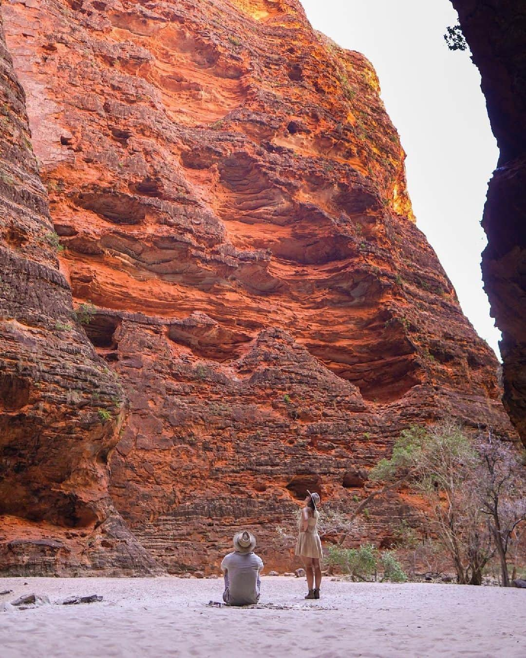 Australiaさんのインスタグラム写真 - (AustraliaInstagram)「Dramatic red rock walls and hauntingly beautiful acoustics? #CathedralGorge, you're the star of the show 🌟💃 Beautifully captured by @4x4weekender, this ancient natural amphitheatre in @australiasnorthwest has us gearing up for an adventure through the World Heritage-listed #PurnululuNationalPark, where treasures like this can be found among the impressive domes of @westernaustralia's #BungleBungle Range! Check out our link in bio for more #bucketlist moments in #Purnululu ☝️✅   #SeeAustralia #ComeAndSayGday #WATheDreamState #AustraliasNorthWest #MagicKimberley @thekimberleyaustralia  ID: A woman standing beside a man who is seated on the ground as they both stare up at the towering red rock walls of Cathedral Gorge in Purnululu National Park」9月25日 5時00分 - australia