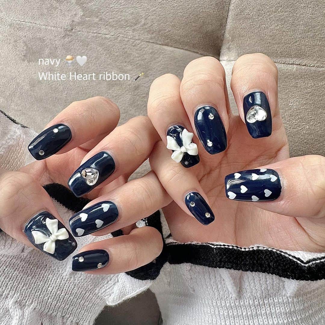 ひなたろす（佐原ひなた）のインスタグラム：「秋になってきたから🍂🌰 深みcolorのネイビー♡  初めてやったcolorなんだけど 可愛すぎた🍂🪄 ribbon🎀　Heart ♡ stone 💎  を乗せて　#ガーリーネイル   担当は、、  @bmoon_mizuki  さん いつもありがとうございます♡  銀座のネイルサロンだよ〜！！ みんなもお揃いしに行ってみてね🤍  @lilybeautynail 💎🎀  #navynails #ネイビー #ネイビーカラー #ネイルデザイン #秋ネイル #フレンチガーリー #ribbon #リボンネイル #ハートネイル #ショートネイル #シンプルネイル #トレンドネイル #ネイルアート #韓国ネイル」