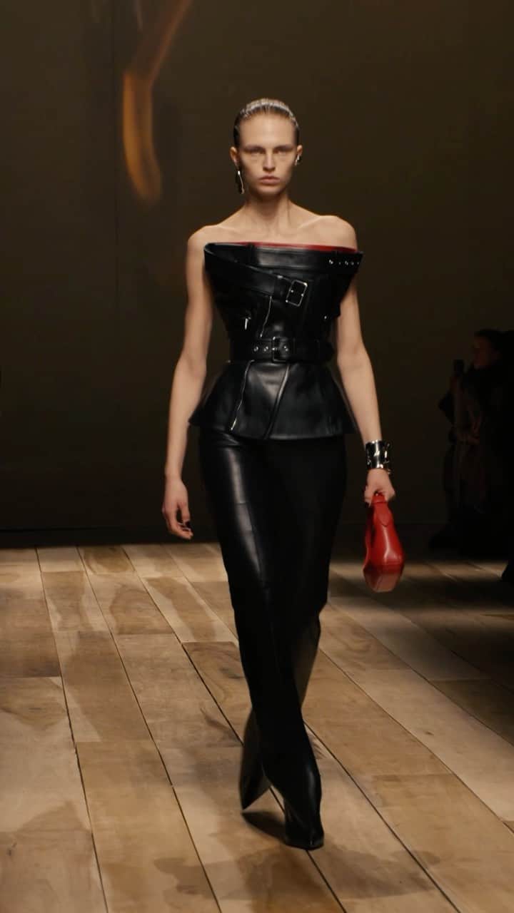 アレキサンダー・マックイーンのインスタグラム：「A wrapped biker corset and heeled trousers in black with the red Mini #McQueenHoboBag.   Discover the #McQueenAW23 collection via the link in bio.   Video by @indigital.tv  Sleep cycling by Rob Lewis Now Is Written and performed by Rival Consoles Courtesy of Erased Tapes 23:52 Written by Nils Frahm & Olafur Arnalds Performed by Nils Frahm & Olafur Arnalds Used by Permission of Manners McDade Music Publishing Ltd. Courtesy of Erased Tapes」