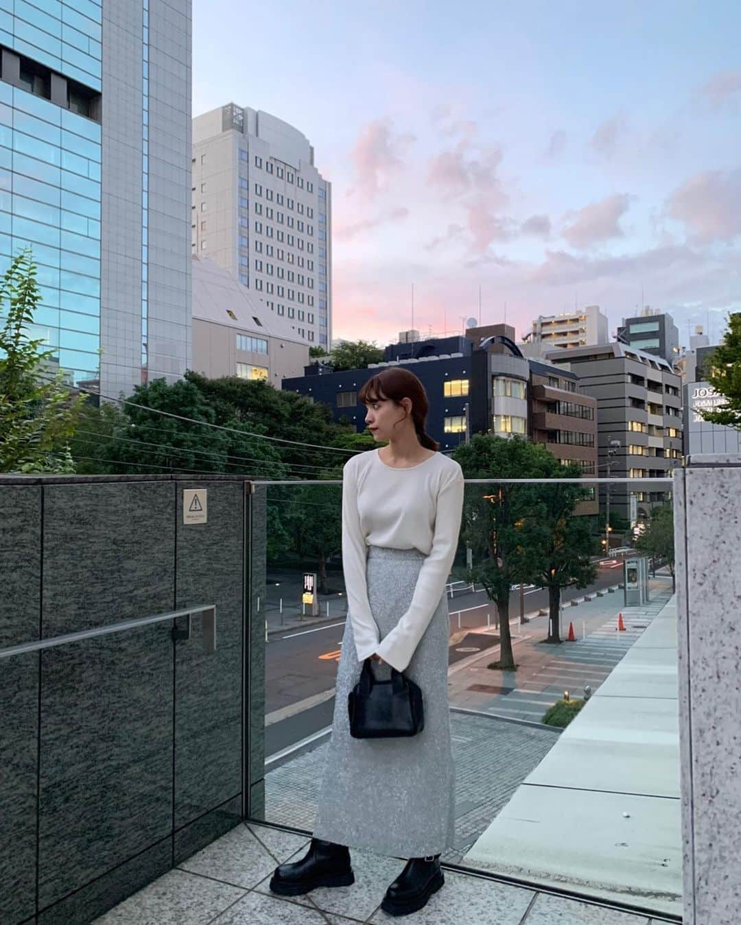のインスタグラム：「🌆✨　  夕焼けをバックに🧡　  ここ数日雨だったから、久々の夕焼けが嬉しくて 夕日が沈むまで外にいたら見事に蚊にさされた🥹💫　  . コーデ詳細↓  トップス @manof_official  シンプルだけど背中がちょっと空いてて、程よく肌見せできるのが可愛い♡秋の肌見せ🍂 生地も気持ちよくて高見えだし、あと袖が長いのも好きなポイント🤍  スカート @searoomlynn_official  もう既に何回履いているだろうか… 今季挑戦中の可愛い可愛いギラギラシリーズ🪩♡ ラメでも着回し抜群だからかなりおすすめ🫶買って良かった！ .  やっとでちょっと秋らしくなってきたよね🍠 クーラーじゃなくて外の風が部屋に入ってきて心地良いの、念願だったの😮‍💨  #秋コーデ  #夕焼け　 #🧡」