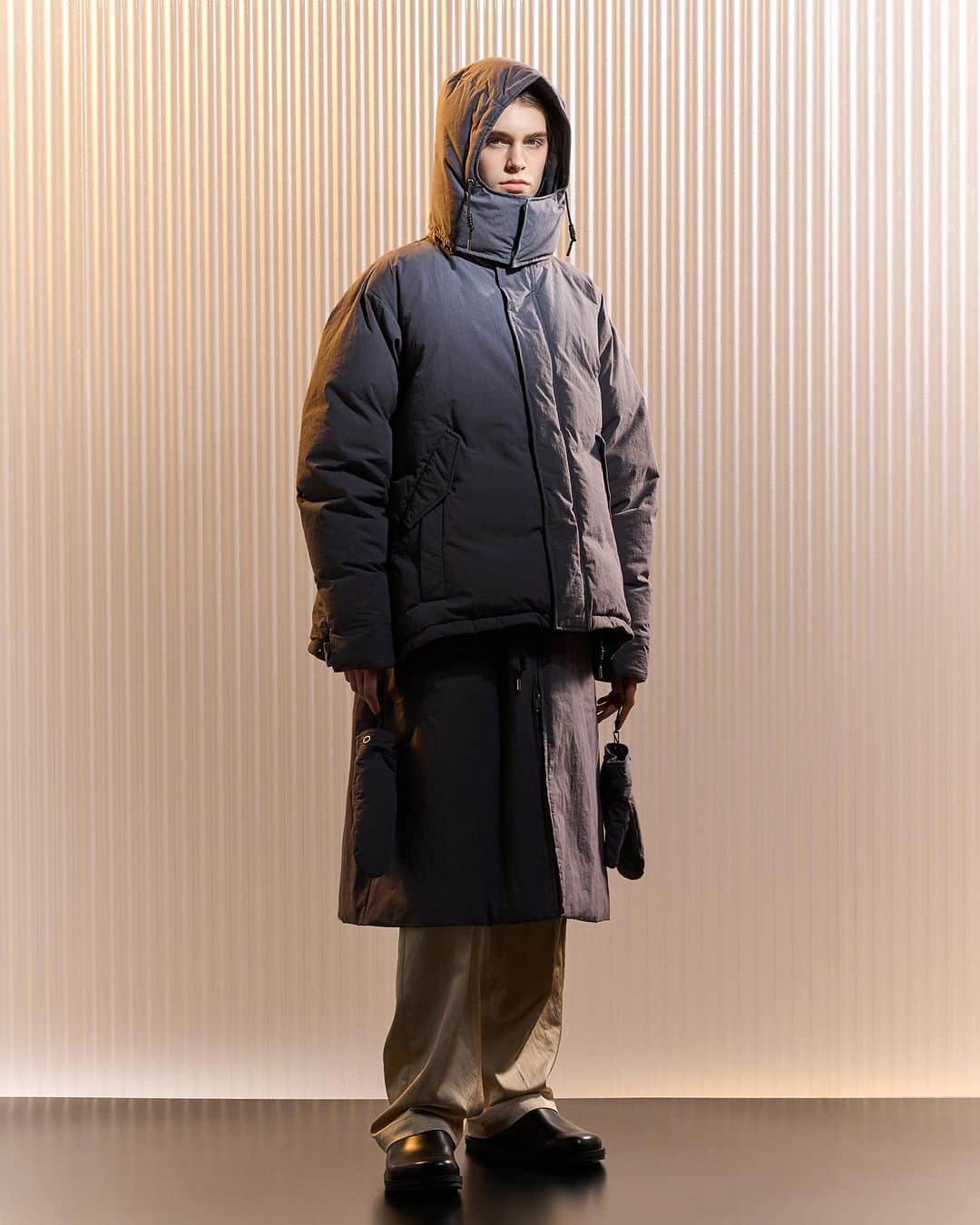 ミーンズワイルのインスタグラム：「meanswhile × IHNN Capsule Collection  レディースブランドIHNNとのコラボレーションウェアを発売します。 ブランドとしてはじめてのウィメンズアイテムを製作しました。 Our collaboration with womenswear brand IHNN is now for sale.   meanswhile の「日常着である以上、服は衣装ではなく道具である」というコンセプトと、IHNNの「パーソナリティを際立たせる」スタイルを組み合わせて、人々が自分自身を表現する「パーソナリティの工具」というアイデアを中心に据えたカプセルコレクション。 Our first time creating women’s pieces, our philosophy of “clothing as a tool of daily wear” and IHNN’s concept of clothing that “brings out your personality” combines to inform a collection under the idea of “tools of personality,” allowing wearers to freely express themselves.  3D Creator Lee Jaeyong @imhere_imj  ダウンジャケットは取り外し式のフードや単体でもアクセサリー感覚で着用できるミトン型グローブが付属しています。 ロウ引きコードや首元のレザー使い等、コラボならではのパーツ使いが上品な雰囲気を醸し出しています。 Removable hood down jacket. Comes with a set of gloves that can be worn as an accessory on its own. Features waxed cord and leather neck details to create an elegant finish unique to this collaboration.」