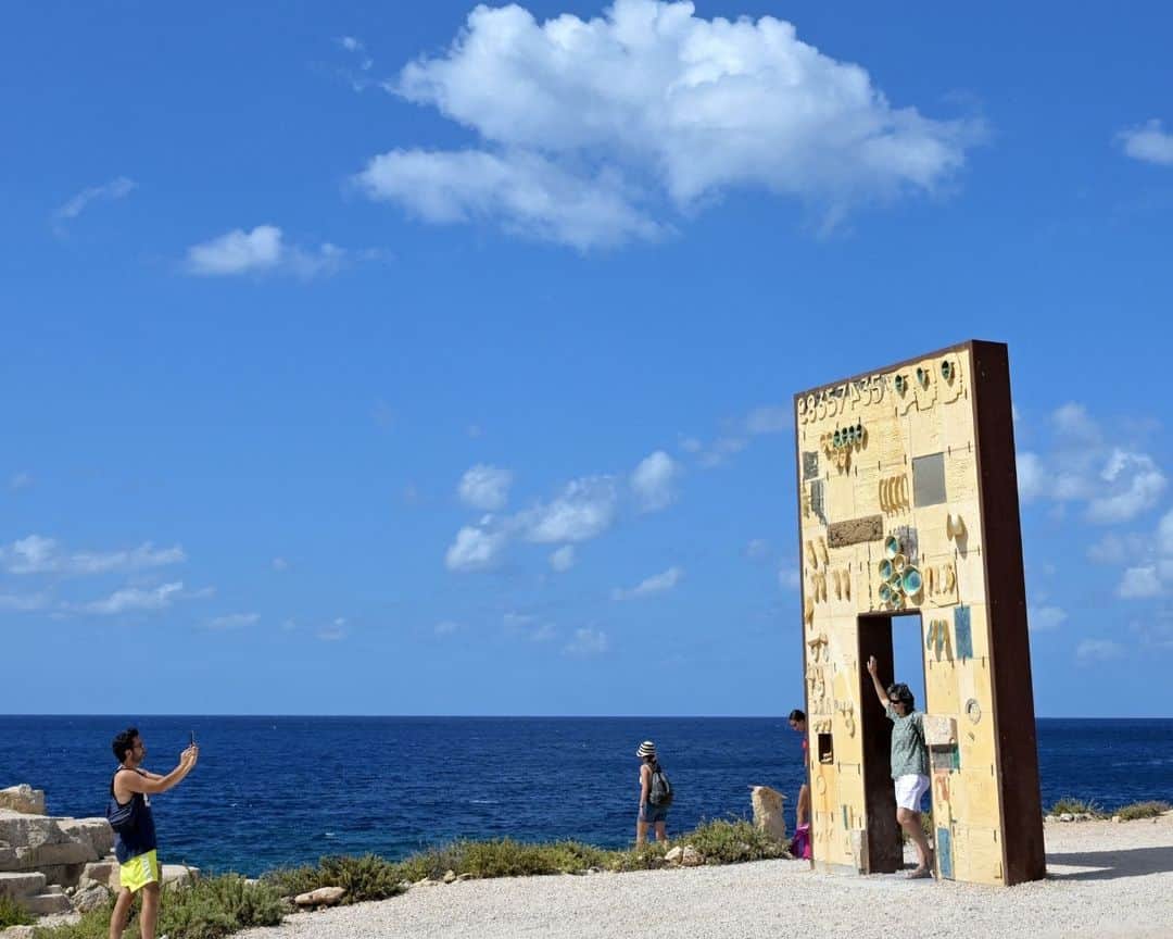 AFP通信さんのインスタグラム写真 - (AFP通信Instagram)「Lampedusa, Italy's southernmost island, has long been a landing point for migrant boats from North Africa.⁣ ⁣ ⁣ 1 - A memorial reading "Yusuf Ali Kanneh, Libia 16.04.2020 - Mediterranean Sea 11.11.2020" is seen on the wall of the cemetry where victims of shipwrecks are buried, on the island of Lampedusa.⁣ ⁣ 2 & 3 - Wooden crosses made with the remains of boats used by migrants to cross the Mediterranean sea are seen in the cemetry where victims of shipwrecks are buried, on the island of Lampedusa.⁣ ⁣ 4 - Tourists take photos at the "Porta di Lampedusa", known as "The door of Europe", a monument dedicated to the migrants who have died in the Mediterranean sea trying to reach Europe⁣ ⁣ 5 - Shoes are hanged on the "Porta di Lampedusa" monument.⁣ ⁣ 6 - Boats used by migrants to cross the Mediterranean sea are abandoned on the beaches of Lampedusa.⁣ ⁣ 7 - Clothes and a tube used as a buoy are abandoned in a wooden boat used by migrants to cross the Mediterranean sea, on the island of Lampedusa.⁣ ⁣ 📷 @tittifabi #AFP」9月26日 20時01分 - afpphoto