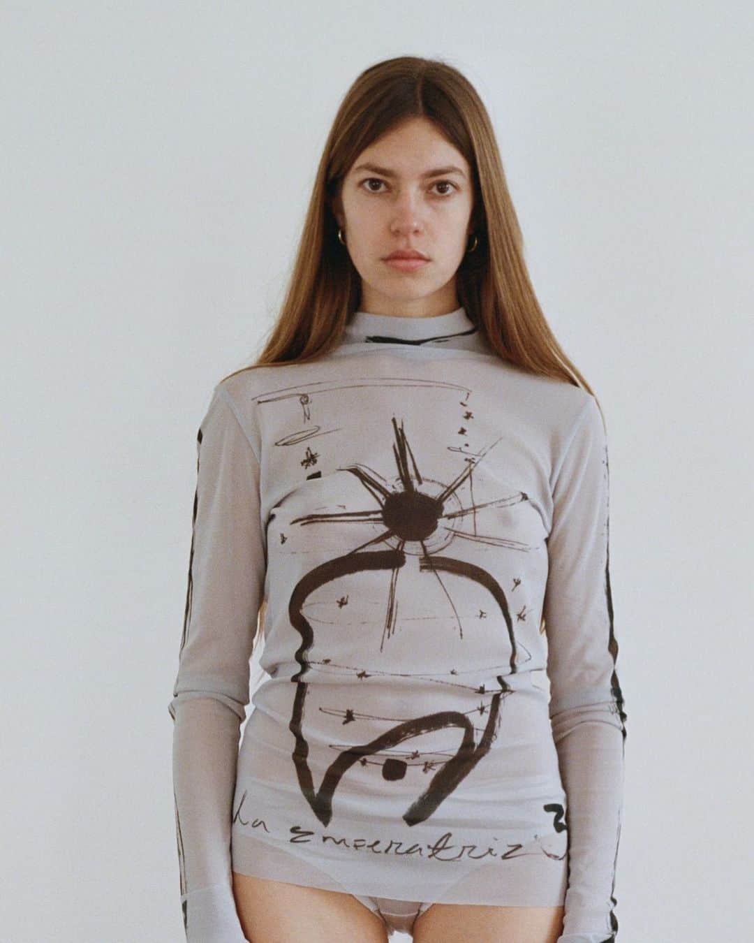 のインスタグラム：「23AW collection - Collaboration with Mayte nicole  AW23 collection にて初のコラボレーションとなる  Paris在住の画家「Mayte nicolee」 との collaboration item を紹介  【 Mayte nicole 】 instagram :  @maytenicolee Photograph @neigeaugustaceleste   I was born and raised in the dominican republic ,  I now live in paris. I’ve always been inclined to express my creativity in every possible way-  how I sleep , how I eat, how I dress.  It’s a constant game which i think  its very helpful for anyone who struggles  with the heaviness and raw nature of ‘’reality’’.  Through my drawings i create an escape  and try to materialize a much bigger perspective  and an oniric way of seeing  and feeling emotions and situations.  By drawing stars, planets, angels,  nature, androgenous figures, movement... Paper offers an energy to my process of sensibility  and nobleness that sums peace and warmth to my work,  while the ink always brings boldness and strength.  I project a lot of feelings onto my work,  and a lot of healing lies behind these papers.  I work in series most of the time because  it makes me feel less pressured for a result  and in the process i become a child again,  is what i enjoy the most.  I move from country to country a lot so the fact that my work is light in weight makes me feel free.  I have an obsessive behavior, and it translates  into the amount of work i produce,  nature has no limits in how it expands,  i like to imitate nature and its wild behavior when i work.  私はドミニカ共和国で生まれ育ち、 現在はパリで暮らしています。  以前から私は睡眠や食事、 ファッションなどの日常生活において、 あらゆる方法で自らの創造性を表現してきました。  それは「現実」の重さや ありのままの自然に苦しむ人にとって、 非常に役に立つ絶え間ないゲームだと考えています。  私は私の絵を通して逃げ場を作り、 感情や状況に対する視覚・感覚をより大きな視点と 幻想的な方法で形にしようとしています。  星、惑星、天使、自然、中性的な人物や動作… 紙は私の感受性と高貴さにエネルギーを与え、 私の作品に平和と温かみをもたらし、 そしてインクは常に大胆さと強さをもたらします。  私は自身の作品に多くの感情を映し出し、 そしてその紙の裏には多くの癒しがあります。  私はほとんどの時間、シリーズものに取り組んでいます。 それによって結果に対するプレッシャーを感じにくく、 その過程でまた子供の頃に戻れることを最も楽しんでいます。  普段、国から国へと移動することが多いため、 仕事の重圧が軽いという事実に開放感を感じています。  私は取り憑かれたように行動することがあり、 それが私の生み出す作品の量に反映されています。  自然の広がりに制限はなく、 作品作りにおいても自然と その野生を模倣することを好んでいます。」