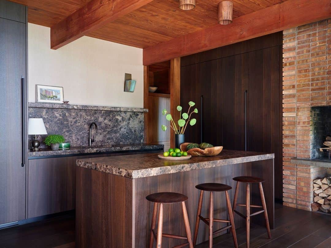 のインスタグラム：「In this midcentury gem located on the shores of Lake Michigan, Architect Celeste Robbins (@robbinsarchitecture) revamped the kitchen with a design by the Italian firm Boffi (@boffi_official) to make way for floor-to-ceiling hidden storage. “The kitchen is on the small side, but I love it and it’s where people always want to be,” says Robbins. “I hid the appliances, so it almost feels like another living space.” Here, the counters and sink are in a dark emperador marble. The ceiling lights are by Allied Maker (@alliedmaker).   To see inside this midcentury gem, click the link in our bio. Written by @alyssawbird. Photographed by @rogerdaviesphotography.」
