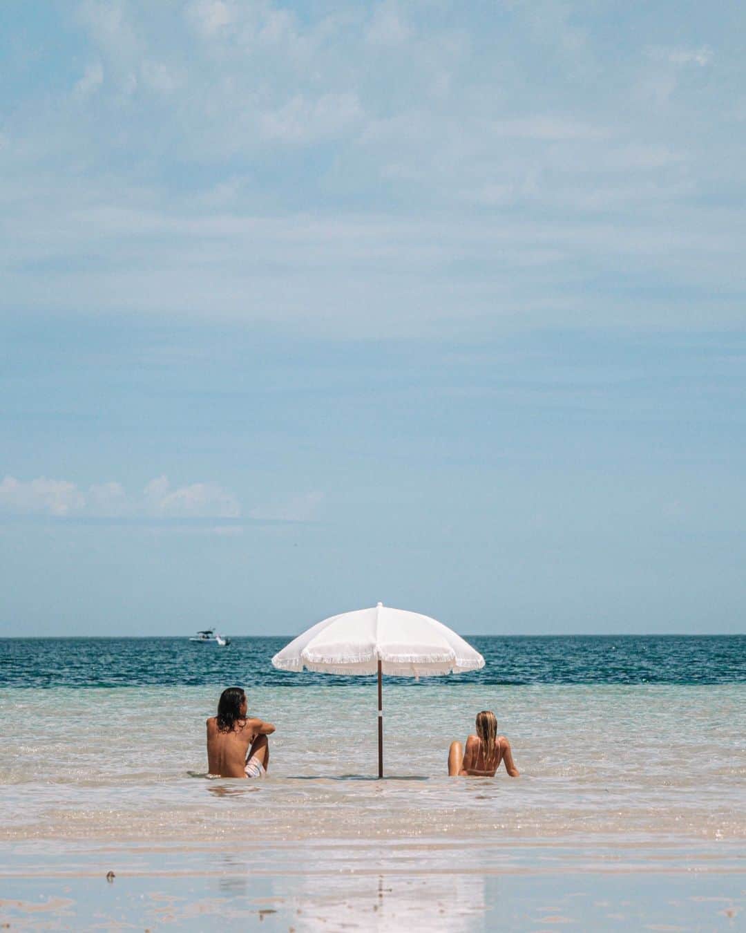 のインスタグラム：「Happy World Tourism Day! 🦘From vibrant cities buzzing with mouth-watering foodie scenes to epic landscapes that will leave your jaw on the floor and unique wildlife ready to show you around their backyard - #Australia has a little something for everyone. Not sure where to start? Find your perfect adventure Down Under via the link in our bio! 🔗   #SeeAustralia #ComeAndSayGday  ID:  1. A man and a woman lounge in the beach's clear blue shallows, shaded by a white umbrella. 2. An Indigenous guide and two travellers stand in the centre of a gorge with towering red rock walls.  3. Five wetsuit-clad people float down a rainforest river on red inflatables.  4. Two hands lightly touching an Indigenous dot painting.  5. A seafood platter sits atop a wooden table on a white sandy beach with endless turquoise ocean in the background.  6. A kangaroo leans to the left for a scratch. He stands in between two rows of vines at a winery.  7. A woman stands in a Melbourne laneway, admiring the street art that paints the walls.」