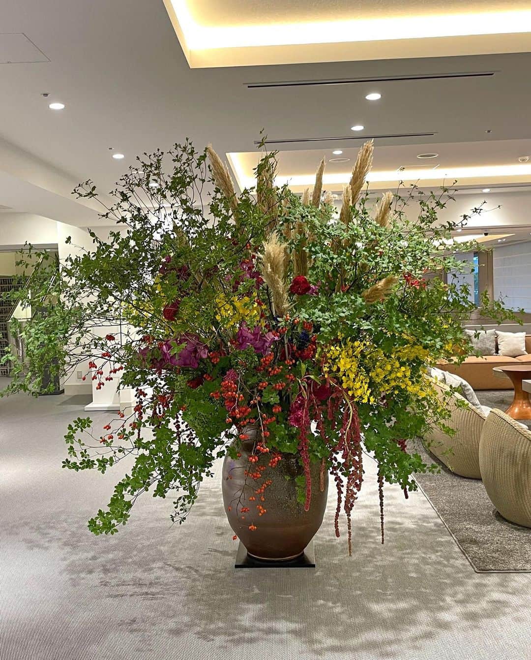 AOYAMA_HANAMOさんのインスタグラム写真 - (AOYAMA_HANAMOInstagram)「装花のご紹介（秋の装花-1） ・ ホテルエントランスを飾る巨大な活け込み。ドウダンツツジとパンパスグラスでシルエットを作り、ケイトウ・スズバラ・アマランサスなどの秋ならではの花材で中央を構成しました。オンシジュームやバンダなどの鮮やかな花も織り交ぜた、インパクトある仕上がりです。 ・ オンシジュームのイエロー、バンダのピンク、ケイトウのレッドなど、原色の分量を適度に抑えたことで上品さを保っています。また、アマランサスやスズバラなど、下垂する花材を使うことでボリュームと動きを出しました。どこから見ても美しくなるよう、たくさんの花材を使い、四方見（しほうみ）で作っています。 - - - #aoyamahanamo #青山花茂 #表参道の花屋 #お花のある生活 #花が好きな人と繋がりたい #花を飾ろう #花のある暮らし #花のあるくらし #花のある日常 #ドウダンツツジ #パンパスグラス #ケイトウ #スズバラ #アマランサス #オンシジューム #バンダ #枝物 #装花 #活け込み #青山花茂活け込み #ホテル装花 #エントランス装花 #ロビー装花 #季節の装花 #秋の装花 #インテリアフラワー」9月28日 10時00分 - aoyama_hanamo