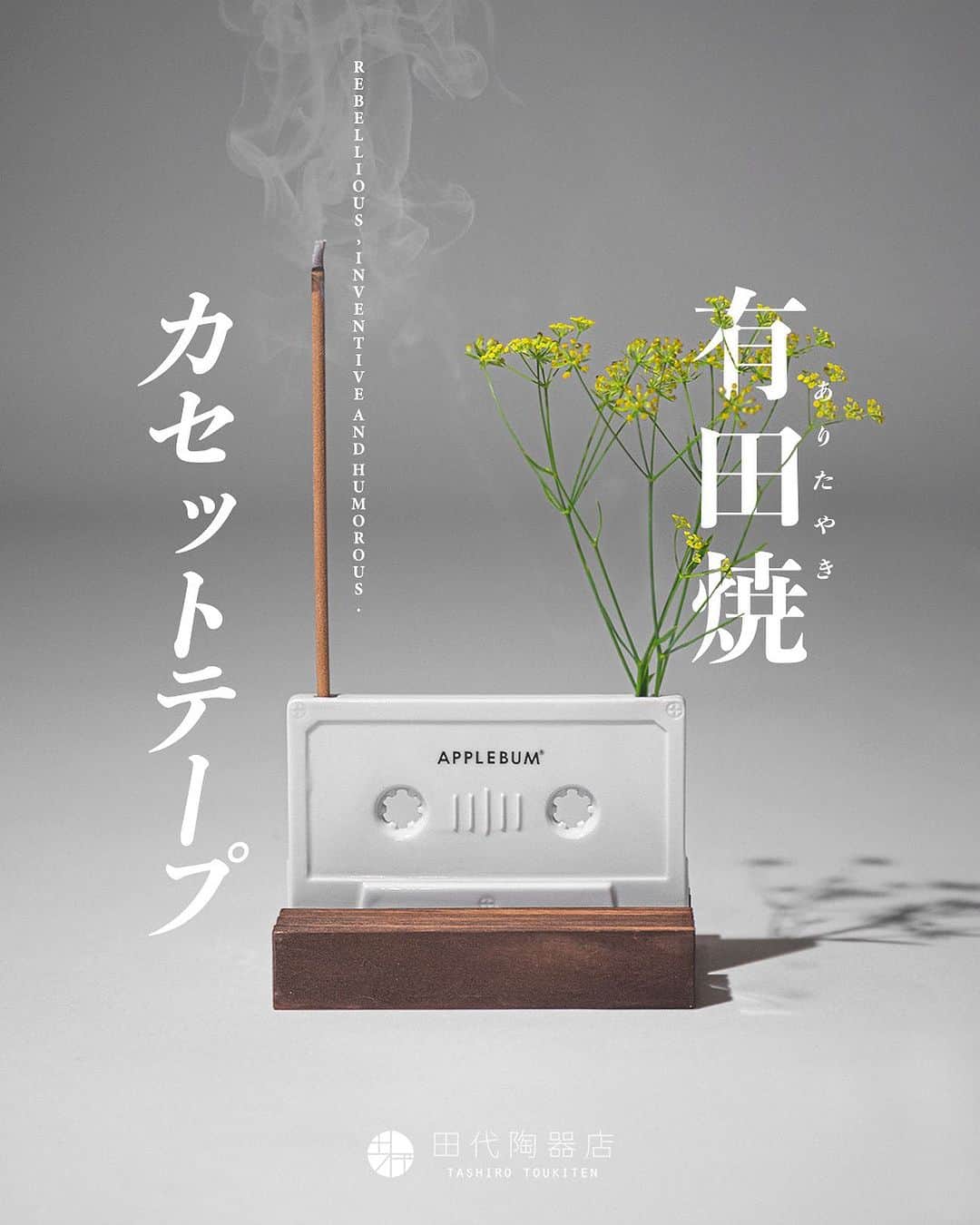 のインスタグラム：「【有田焼 カセットテープ型一輪挿し】  APPLEBUM | 田代陶器店 @applebum_tokyo @tashiroarita  400年以上の歴史を持つ”有田焼”で製作したカセットテープ型一輪挿し。 日本が誇る伝統工芸とAPPLEBUMが愛する音楽カルチャーが融合した、今までに無い革新的一品が誕生しました。  お花を活ける以外にもお香立てや、インテリアとしても大きな存在感を放ってくれるアイテムです。 実際のカセットテープと同じサイズに仕上げました。 木製の台が付属となります。  #applebum #有田焼」
