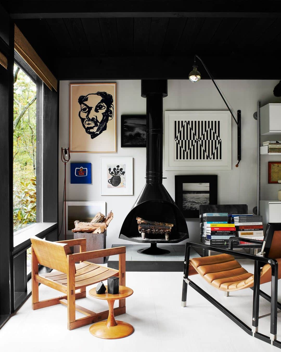 のインスタグラム：「A Dublin native, designer Carol Egan (@studiocarolegan)   grew up between Edwardian and Tudor spaces that were far from minimalist. Her ethereal glass-walled home in Amagansett, New York, is a different matter entirely. The collected look of her home’s interior, she says, “is very autobiographical.” Except for a few contemporary pieces, everything in the home is from the ’50s, ’60s, and ’70s, bought during trips to Europe or at stateside auctions. Here in the living room, a cone fireplace original to the house is the focal point. The vintage armchair (left) is by Edvin Helseth and the vintage side table by Nanna Ditzel. The artworks are by Jack Ceglic (portrait), Carmen Herrera (black and white print), and Larysa Sendich (archival print, below).  Click the link in bio for the full tour of this magical midcentury home, as featured in our October 2023 Change Issue. Written by @whatpaolasees. Photographed by @richardpowersphoto.」