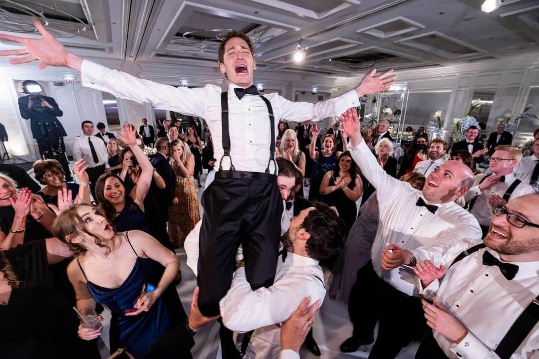 CANON USAさんのインスタグラム写真 - (CANON USAInstagram)「Photo by #CanonExplorerOfLight @bobanddawn_inthewild: "I absolutely adore capturing those high-energy, emotion-packed photographs that pull you right into the moment. Look at this gem from Hannah & Jared's wedding - you can almost hear the music and feel the excitement just by looking at it.  Now, let me share a little secret with you. I live by this motto: ‘Always be prepared.’ So there I was, smack in the middle of the dance floor, armed with my trusty Canon EOS R5, and you bet I had that face/eye detection feature cranked up. I opted for the Zone AF mode, which gives me this handy box to control where my focus goes. Back in the old days of photojournalism, we used to call this move a "hail Mary" - holding the camera above your head, praying you'd nail the shot. But not anymore! With that large LCD flip screen, I could hold the camera high and tilt the screen downwards, right towards me. No more guesswork; I could frame and capture those moments like a pro.  Now, lighting. I had not one, not two, but three off-camera Speedlite EL-1's in the game, all sporting those full CTO (correct to orange) gels. I dialed the camera's white balance to Tungsten to ensure no funky color shifting. You know what I'm talking about - that awkward moment when your subject looks like a glowing angel against an orange backdrop. Yeah, that's what we're avoiding here.   Oh, and here's the kicker - my on-camera Speedlite was always in ETTL mode, while those three off-camera Speedlites were each in their own groups, so I could boss them around individually. In this particular scenario, they were all set to manual flash output at 1/8th power.   I've honed this technique over the years - the ‘Triangle of Light.’ It's my secret sauce for adding layers of light without overpowering the natural ambiance. Trust me; it's all about being prepared for that epic moment rather than chasing it.   Just picture it: the groomsmen lifting Jared high into the air, his face beaming with pure joy, and the expressions of everyone around him - it's simply priceless. 📸🎉"  📸 #Canon EOS R5 Lens: RF15-35mm F2.8 L IS USM」9月28日 0時14分 - canonusa