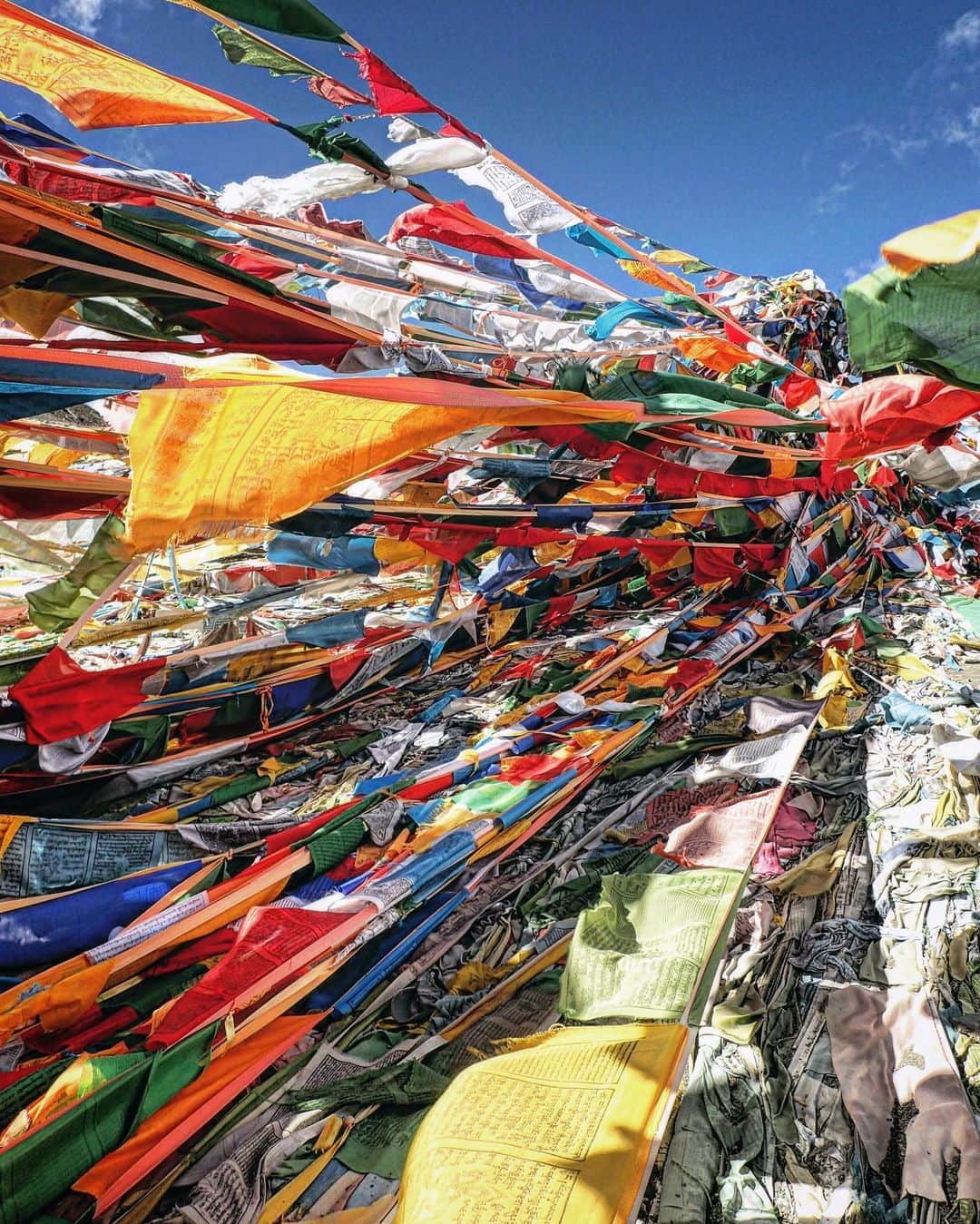 石川直樹のインスタグラム：「For Himalayas➉ Moving to the mountains. #Tibet. 標高5000mの峠を越えて、ニューティンリー着。1枚目の写真は、2つまえのポストと同じ峠です。10年前と今。#タルチョ が増えまくってる。 4枚目は、今日チョオユー組とシシャパンマ組に途中で分かれた際の荷物の積み替え風景。 5枚目はシシャパンマを望む展望台にあった地図。昨日泊まった国境の街、キロンは「吉隆」と書くんですね。 6枚目は、さっき着いたばかりのニューティンリー。10年前も2001年も、ぼくはオールドティンリーに泊まったのでした。ニューティンリーは発展している普通の街。 明日はオールドティンリーを経由して、チョオユーのプレBCへ。#チベット にいるってだけでワクワクしてます。」