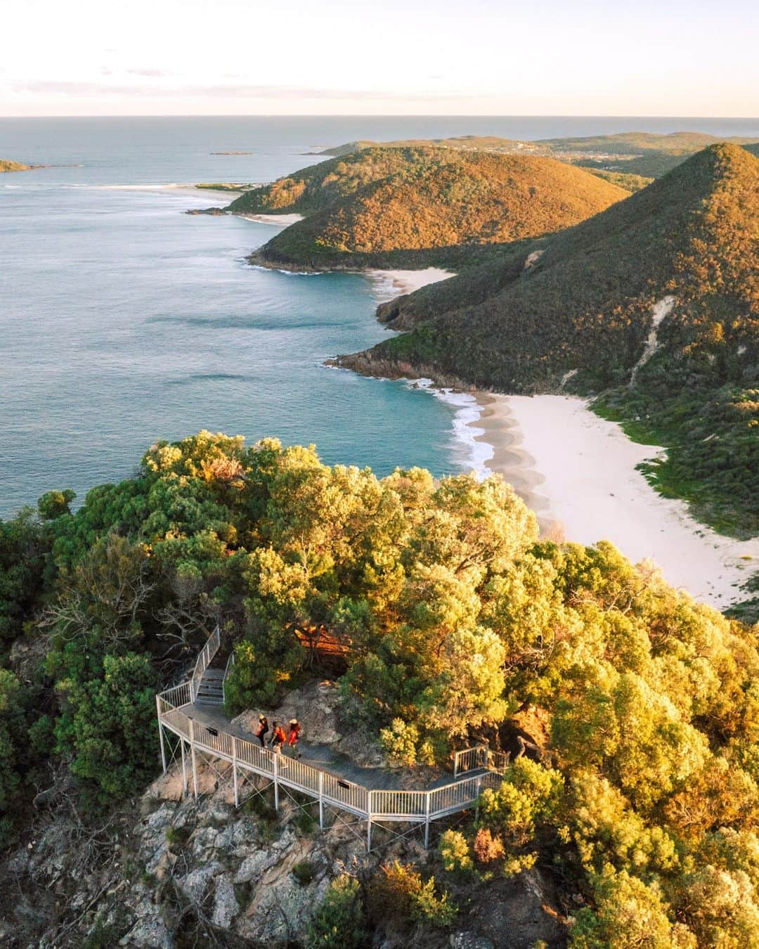Australiaさんのインスタグラム写真 - (AustraliaInstagram)「Lace-up those hiking boots, folks! 🥾 From summit views to sand dunes, the brand-new Tomaree Coastal Walk is a 2-3 day trek through Worimi Country. Kicking off at #TomareeHead in @visitnsw's #ShoalBay, walkers will be treated to dazzling ocean vistas, sparkling beaches, unique rock formations and an abundance of flora and fauna, before wrapping their journey at the majestic sand dunes of Worimi Conservation Lands in @visitportstephens - the largest moving dune system in the southern hemisphere!🌿👣   #SeeAustralia #ComeAndSayGday #FeelNSW @nswnationalparks   ID:  1. Three people walk on white sand towards turqiose water along an orange rocky coastline. 2. Three people walk along a trail through thick green vegetation. To the left, is a small rocky beach.  3. Three people stand on a coastal lookout. Mountains and sandy beaches dot the coastline behind them.  4. Three people walk through a dense rainforest. Sun filters in through the leafy green trees.」9月29日 5時00分 - australia