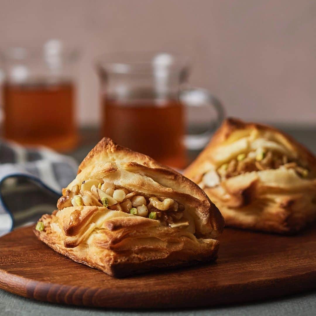 ANDERSEN アンデルセンのインスタグラム：「秋のスコーン🍂 ハニーナッツのびん詰めをイメージした 秋らしい味わいのスコーン🐝  「はちみつとナッツのスコーン」  ザクザクとした食感が特長のデンマークスコーンに ミルククリームを絞り、 はちみつと合わせたナッツをのせ、 ピスタチオの小割で飾りました。  香ばしいナッツとまろやかなはちみつに やさしい味わいのミルククリームが好相性。 風味の良いデンマークスコーンによく合います。  コーヒーや紅茶と一緒にティータイムに ヒュッゲな時間をお過ごしください☕️」