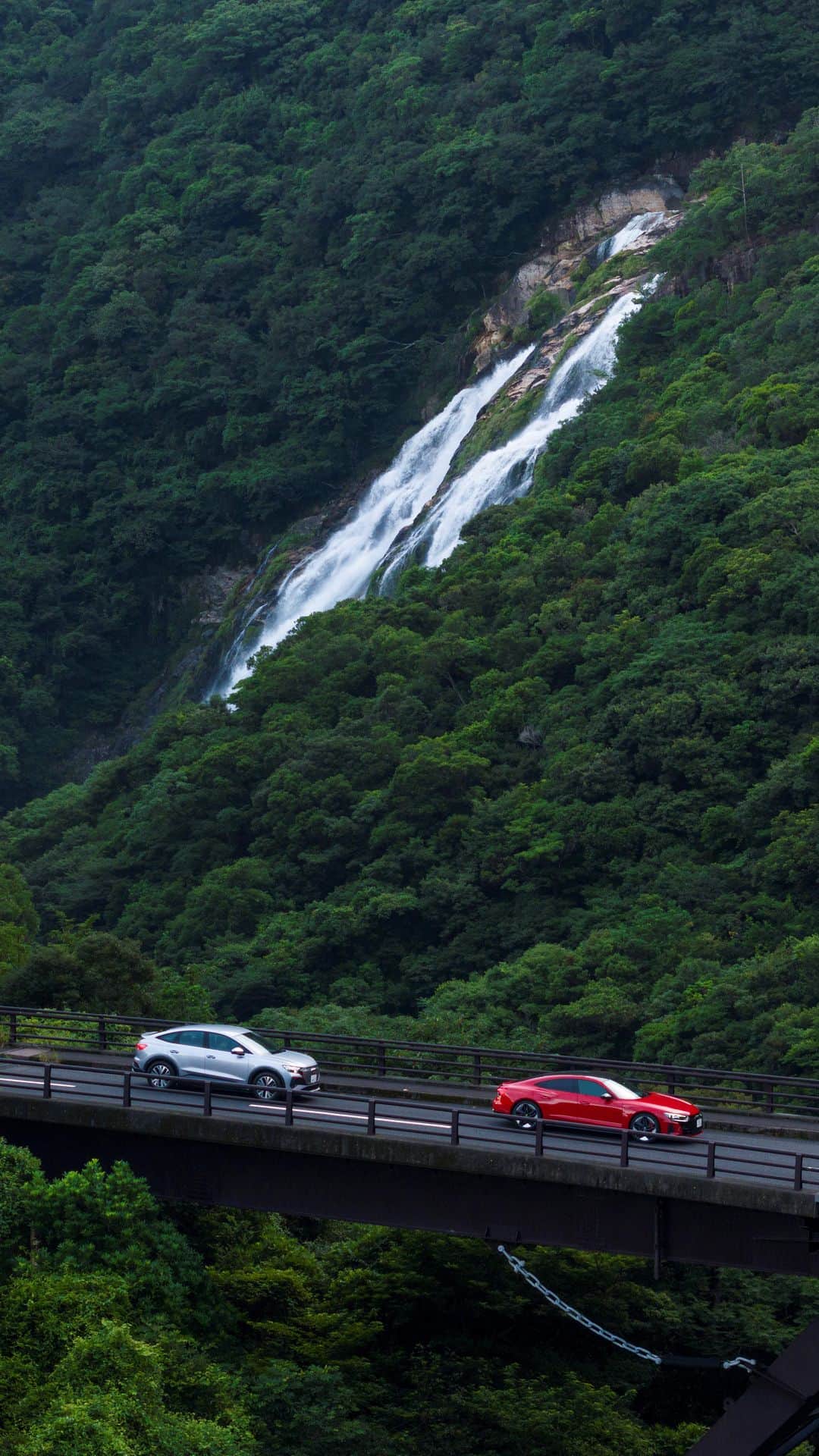 アウディ ジャパンのインスタグラム：「緑に囲まれたワインディングロード、青々とした海、迫力溢れる滝。 自然が作り出す絶景の中でのドライビングは、一生忘れられないものに。   Audiが誇る最先端EV Audi RS e-tron GTとAudi Q4 e-tronが自然豊かな屋久島を走り抜けるドライブムービーをAudi Japan公式YouTubeにて公開中。   先進性を極めた電気自動車と雄大な自然の競演をぜひご覧ください。   #Audi #AudiRSetronGT #AudiQ4etron #EV #屋久島」