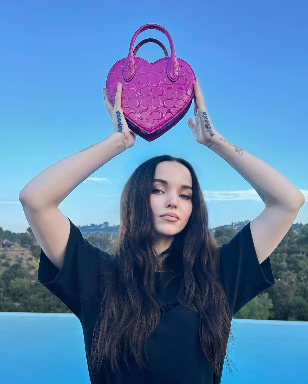 コーチのインスタグラム：「It was love at first sight between @dovecameron and the Patent Signature Heart Bag. 💕#WearYourShine #CoachNY」