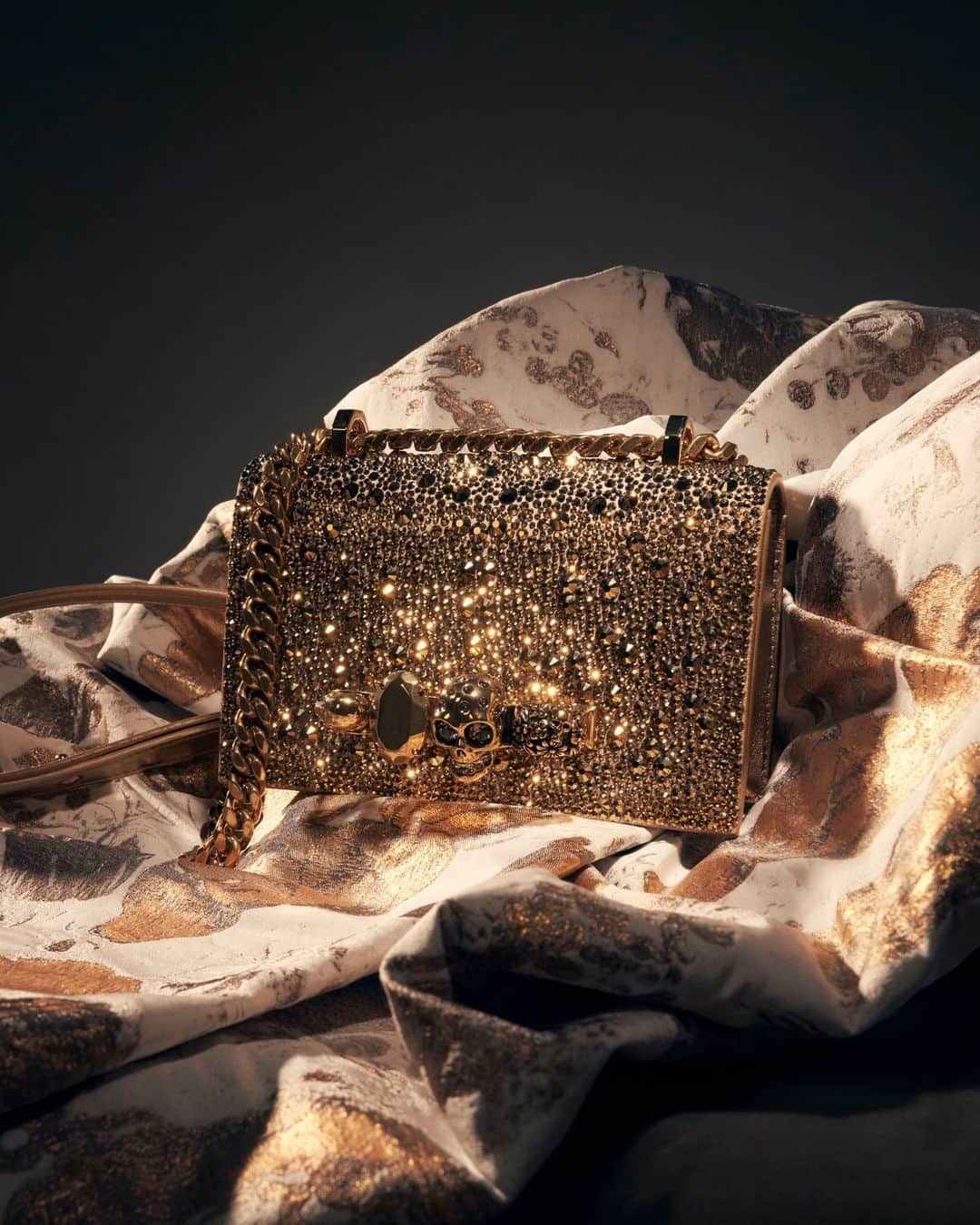 アレキサンダー・マックイーンのインスタグラム：「The Mini #McQueenJewelledSatchel, embellished with all-over gold crystals for the #McQueenGifts collection.⁣ ⁣ Discover the collection via link in bio.⁣ ⁣ Photographed by @maximepoiblanc」