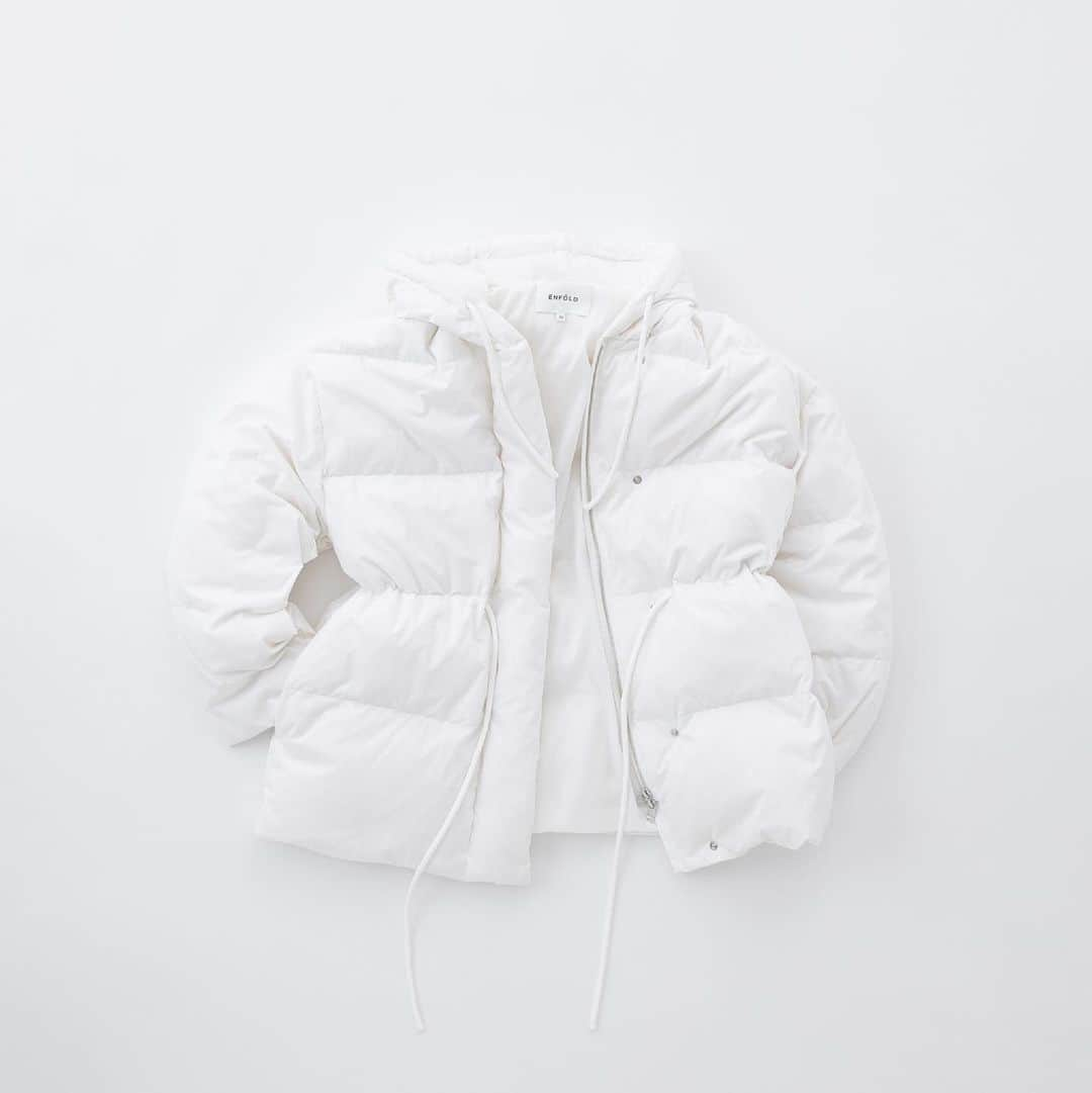 ENFÖLDのインスタグラム：「【MINIMAL DOWN-JACKET】  重たくなりがちなダウンジャケットの印象をミニマルなディティール、パウダリーな質感の生地で軽く仕上げました。 高密度に織り上げられ、マットな表地。それと同じ生地に包まれたスピンドルコードがフードとウエストに仕込まれ、細部までしなやかな印象に。 十分な防寒性、内ポケットの収納もあり、冬の装備をライトにしたい方には特におすすめ。 ウエストのスピンドルでシェイプを効かせたり、スポーティーにもモードにもフィットするデザインなので、気がついたら毎日着ている1着になりそう。  Product No.: 300GA130-2580 Color: WHT Size: 36, 38inch Price: 82,500jpy (tax in) *11月1日Online Store (正午12時), 直営店店頭展開予定。 *直営店店頭での入荷連絡は現在承っております。ぜひ店頭までお問い合わせくださいませ。 *数に限りがございます。ご了承くださいませ。  #enfold_official #enfold #enföld」