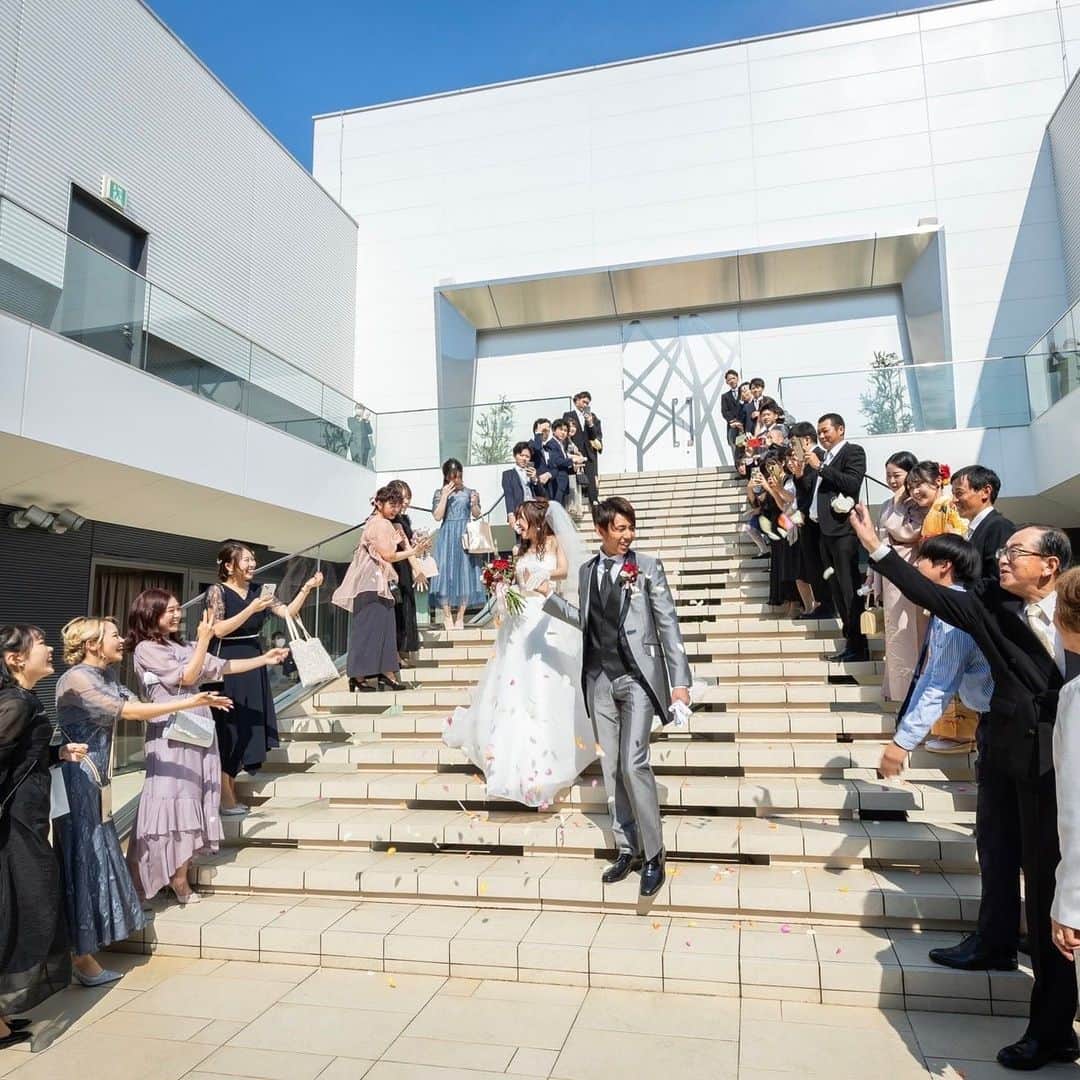 【公式】アルカンシエルリュクスマリアージュ名古屋さんのインスタグラム写真 - (【公式】アルカンシエルリュクスマリアージュ名古屋Instagram)「【大階段でのフラワーシャワー＆ウェルカムパーティ🎉】  アルカンシエルで結婚式を挙げてくださる新郎新婦様に『やって良かった！』と高評価を頂けるのが“大階段でのフラワーシャワー”＆“ウェルカムパーティ”です🥂  青空のもと、気持ち良い風の中で行うフラワーシャワーのセレモニーは、新郎新婦のおふたりもゲストの皆様も笑顔になります☺️💗  また、フラワーシャワー後には専用の会場で“ウェルカムパーティ”がスタート🫶 ビール🍺やカクテル🍸、生ハムのカッティングサービス、一口サイズのフィンガーフードなどをお召し上がり頂けます💕 新郎新婦様とのお写真タイムも楽しめるので、ゲストの皆様にとっても素敵なお時間になります♪  💒名駅徒歩5分の結婚式場  『#感謝を式のまんなかに。』をテーマに、青空を貸切る祝福のステージと上質な空間で生まれる、ゲストとの忘れられない一日のつくりかたを紹介しています💓  👇🏻をタップ🌈👣 @arcenciel.luxenagoya  2023年度版　JapanBrandCollectionに掲載されました 公式アカウント⇨ @japanbrandcollection lit.link/japanbrandcollection  #アルカンシエル #アルカンシエルluxemariage名古屋 #アルカンシエルリュクスマリアージュ名古屋 #アルカン花嫁 #名古屋花嫁 #名古屋プレ花嫁 #名古屋ウエディング #名古屋ウェディング #名古屋結婚式 #名古屋結婚式場 #愛知花嫁 #日本中のプレ花嫁さんと繋がりたい #結婚式レポ #結婚式レポート #ウエディングレポート #ウェディングレポート #ウェディングレポ #ウエディングレポ #花嫁レポ #結婚式当日 #2023秋婚 #2023冬婚 #2024春婚 #2024夏婚 #フラワーシャワー #幸せのおすそ分け #アフターセレモニー #結婚式演出 #ウェルカムパーティー」10月25日 21時00分 - arcenciel.luxenagoya