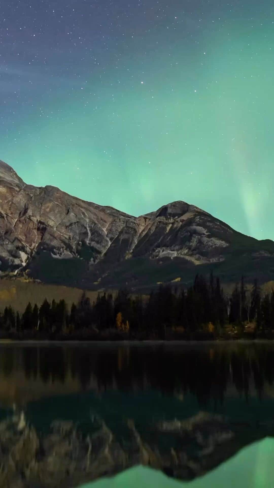 Explore Canadaのインスタグラム：「Did you know? Jasper National Park is the largest accessible Dark Sky Preserve in the world! 🌃  Dark Sky Preserve is an area in which no artificial lighting is visible and active measures are in place to educate and promote the reduction of light pollution.  Jasper celebrates this by hosting a Dark Sky Festival—a three weekend event with cosmic festivities. This year it ends on October 29th, it’s an incredible opportunity for dark sky viewing and out-of-this-world fun! 🌟  📷: @jeanine.holowatuik  📍 : Jasper, Alberta @TravelAlberta @tourismjasper  #ExploreCanada #ExploreAlberta  Video description: Video slowly pans across a mountain lined with trees. Flashes of fluorescent green light highlight a dark blue sky. Stars are scattered throughout the sky.」