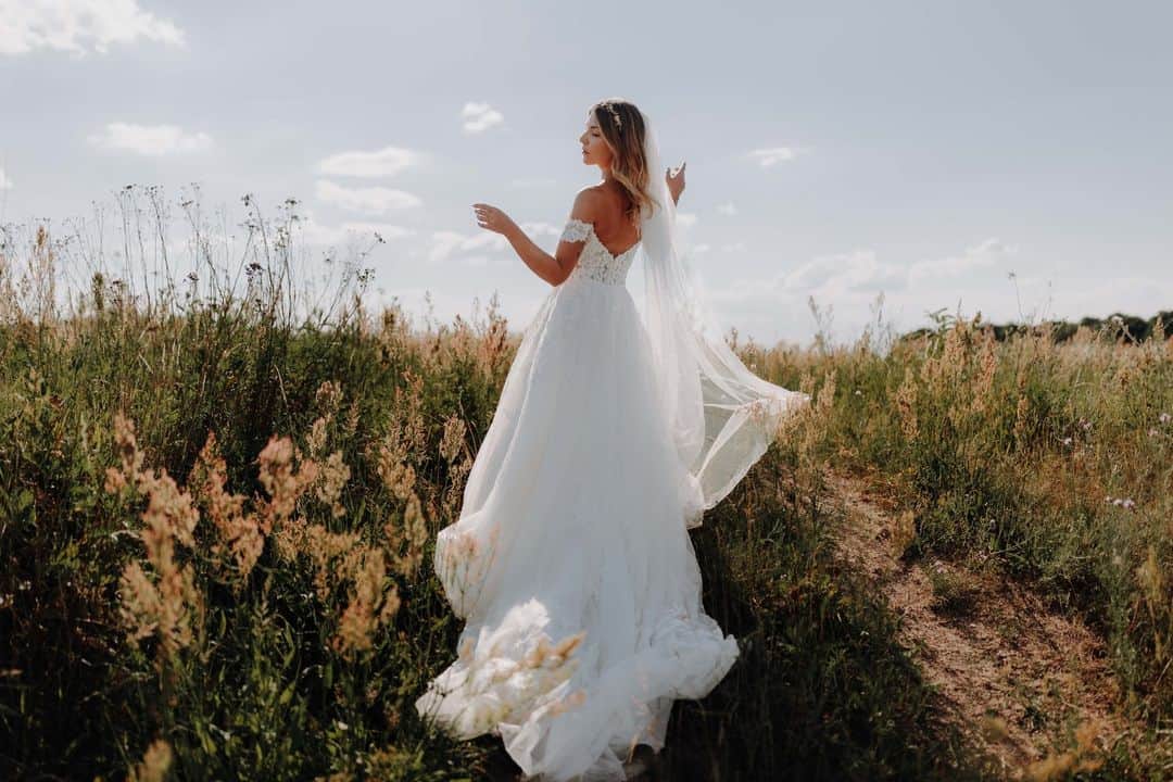 CANON USAのインスタグラム：「Photo by @lindau.weddings: "During this photo, the bride did not notice my presence. She originally got her dress caught in the grass and tried to loosen it. In this shot, it looks like she is playing with the dress in the wind and I love how candid and natural it looks." #ShotOnCanon   📸 #Canon EOS R6 Lens: EF 35mm f/1.4L II USM」