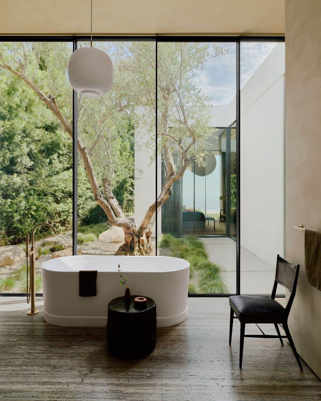 ELLE DECORのインスタグラム：「Washing away the city hustle in this serene bathroom oasis, designed by architects Brett Woods and Joseph Dangaran of Woods + Dangaran (@woods_dangaran) with ELLE DECOR A-List firm Studio Mellone (@studiomellone). “The ceilings are 12 feet tall, which can make it hard to create a house that feels human in scale,” Woods says. The duo used clever compositional elements—built-in wood niches, floor-through sight lines—to visually divide the grander proportions into something more intimate.  Click the link in the bio to tour the rest of this Hollywood Hills house, as featured in our November 2023 issue. Written by @isuredontknow. Styled by @amykchin. Photographed by @william.jess.laird.」
