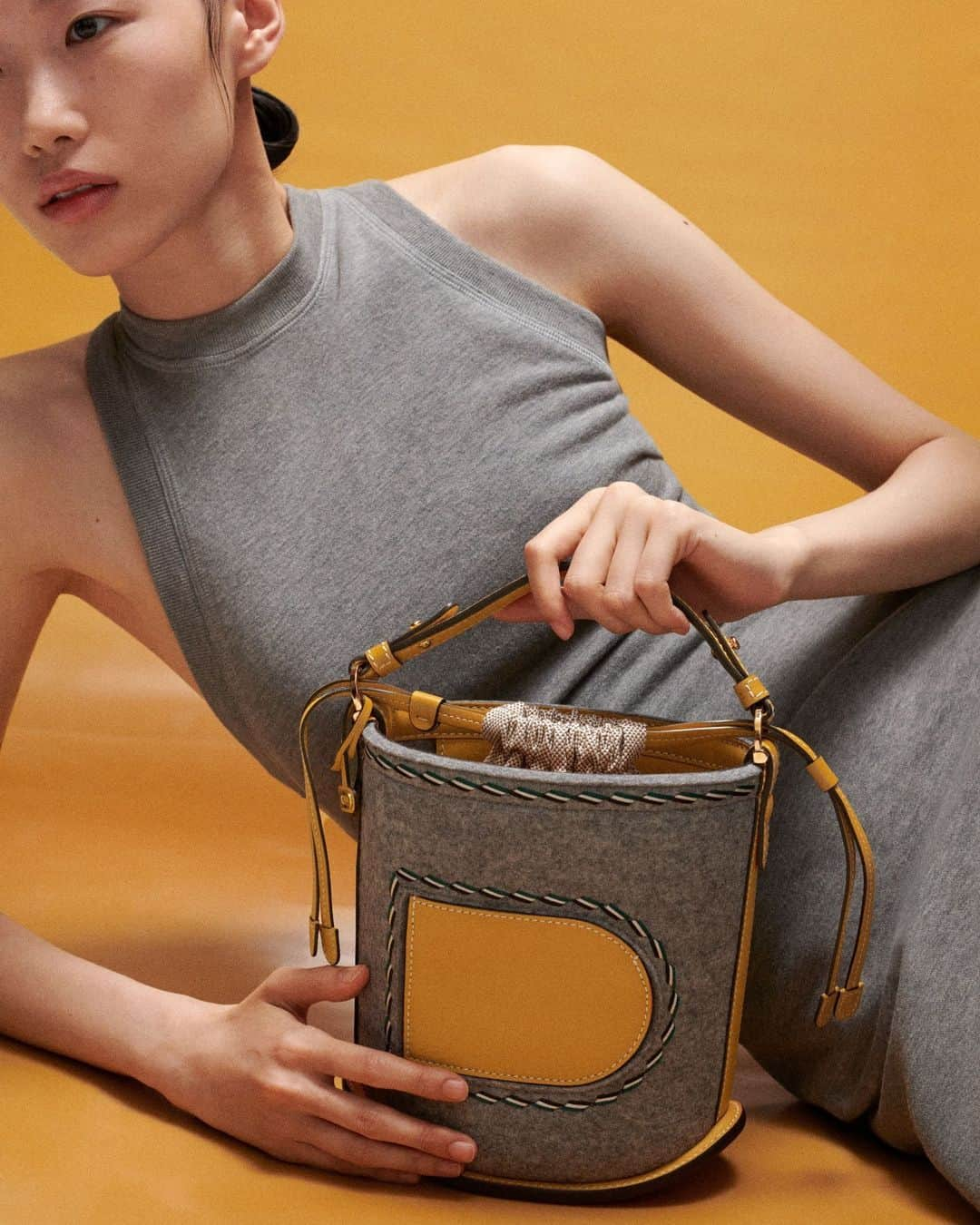 デルボーのインスタグラム：「Grey and saffron-coloured dreams.⁣ ⁣ The perfect autumnal pairing. Rich and grey felt, crafted from 100 percent natural wool, and Sierra Calf leather in a vibrant shade of Saffron combine to give luxurious depth to the Pin Mini Bucket. ⁣ ⁣ #Delvaux」