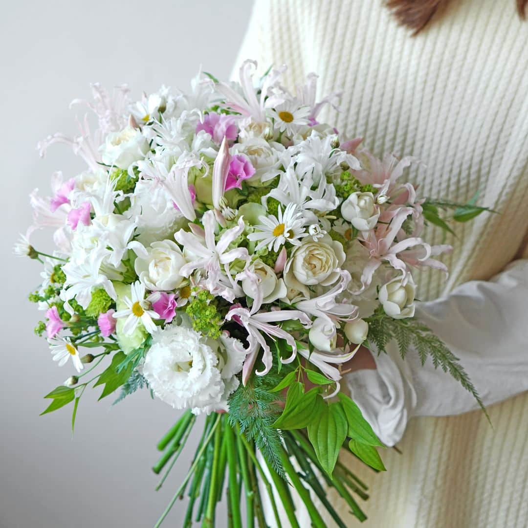 AOYAMA_HANAMOさんのインスタグラム写真 - (AOYAMA_HANAMOInstagram)「重なり合う花々の繊細な美しさに魅せられて。 ・ くるりとカールした花びらが愛らしい淡いピンクと白のネリネ、白いスプレーバラやマーガレット、淡いグリーンのスプレーマムやトルコキキョウ、ピンクのナデシコなど。優しい色彩の花々をふんわりとまとめ、柔らかな印象に仕上げました。 細やかな花々が重なり合って、まるで花畑のようなにぎわいを感じるブーケです。 ・ ネリネという名前は、ギリシャ神話に登場する水の妖精「ネーレーイス」が由来になっています。太陽光を浴びてキラキラと輝く姿が、女神・ネーレーイスに匹敵するくらい美しいとされて名付けられたのだそうです。 今回使用したネリネはボーデニー系という品種群ですが、サルニエンシス系という品種群は特に存在感のある輝きを放ち、別名「ダイヤモンドリリー」と呼ばれています。 ・ ネリネがもっとも美しく咲く時期は10月〜12月。ぜひ、皆さまも旬を迎えたネリネをお楽しみください。 - - - #aoyamahanamo #青山花茂 #お花のある生活 #花が好きな人と繋がりたい #花を飾ろう #花のある暮らし #花のあるくらし #花のある日常 #癒しの花 #季節の花 #旬の花 #花とおうち時間 #花贈り #フラワーギフト #花の贈り物 #ネリネ #ナデシコ #スプレーバラ #スプレーマム #トルコキキョウ #マーガレット #オーダーメイドブーケ #青山花茂おまかせブーケ #花束 #ブーケ #ネリネの花束 #ナチュラルブーケ #ウエディングブーケ #クラッチブーケ」10月26日 18時00分 - aoyama_hanamo