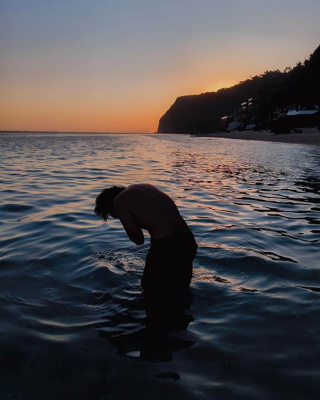 Putri Anindyaのインスタグラム：「Rebirth //   The moodiest sunset with @matthewdjoevan almost two months ago. Always a good time on the sea with him. And i just realized it’s been a long time since I post a picture of him at the Melasti Beach, our fav place to swim since 2016 lol. This beach changed a lot, so did we. Time keeps ticking to the better end. Before I said more of my thoughts, let me just say happy birthday to you @matthewdjoevan , the moon child, the sea creature 🌊 🌙   #portrait #portraitmood #sea #sunset #mobilephone」