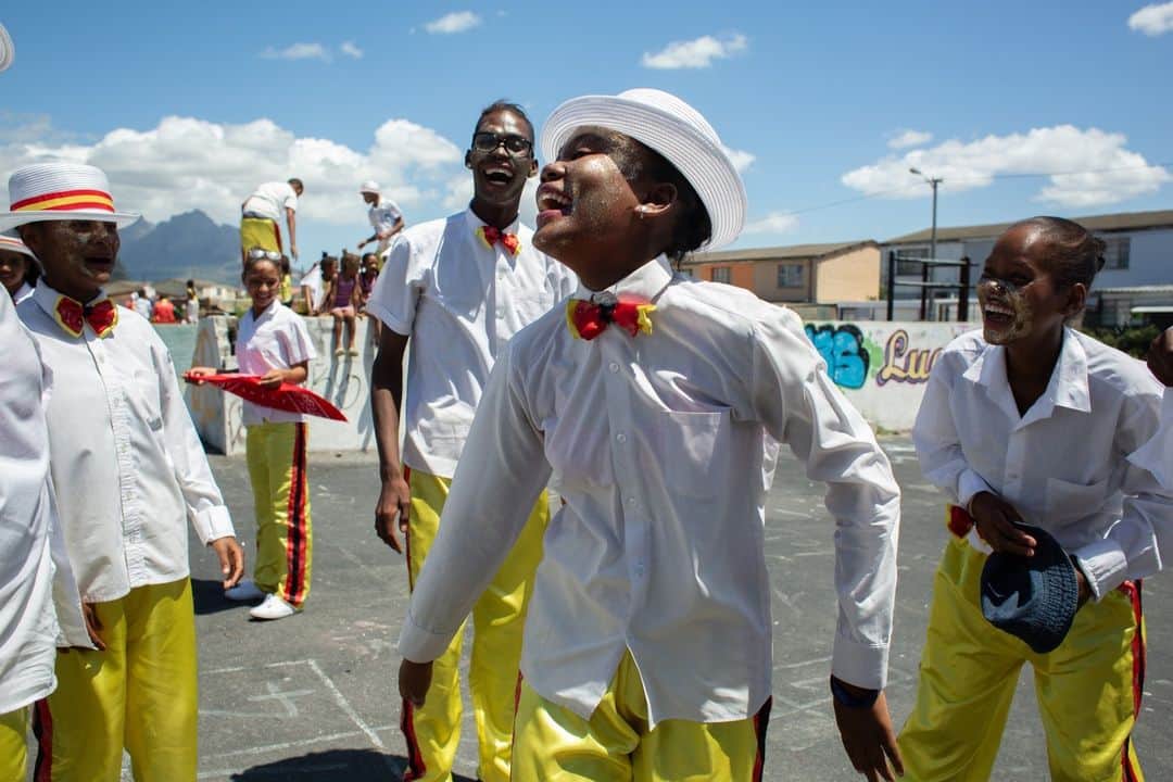 CANON USAのインスタグラム：「Photo by #CanonExplorerOfLight @krisannejohnson: "Friends laugh and gather to march and dance in a local parade as part of Cape Town’s New Year Carnival celebrations. As a documentary photographer, I can often spend days waiting for a moment and nothing happens. But then there is that one day where everything syncs."  📸 #Canon EOS 5D Mark III Lens: EF 28mm f/1.8 USM」